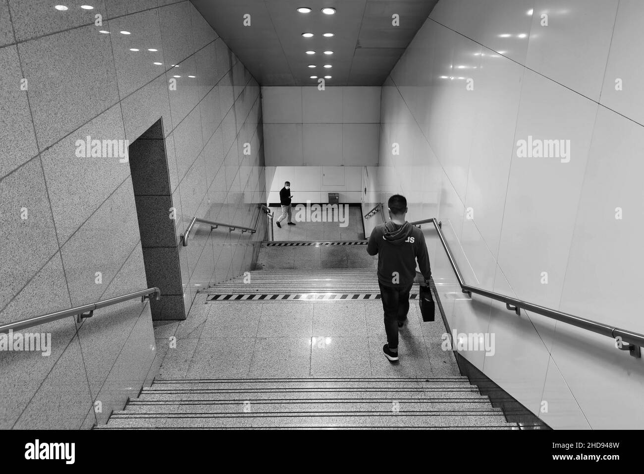 Vista interna di un edificio con un ragazzo che scende le scale Foto Stock