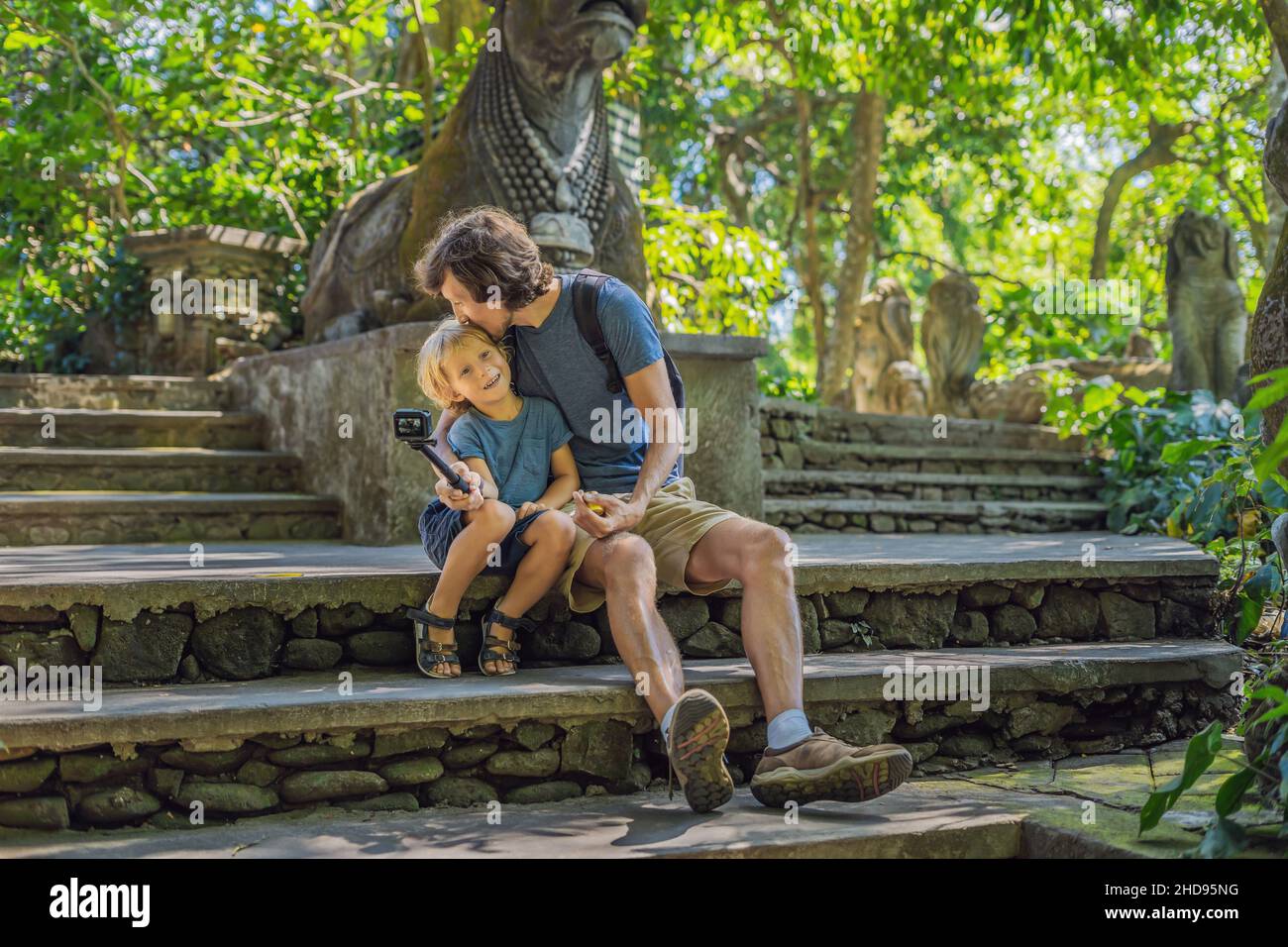 Papà e figlio viaggiatori alla scoperta della foresta Ubud nella foresta delle scimmie, Bali Indonesia. Viaggiare con i bambini del concetto. Videoblog, Selfie. Foto Stock