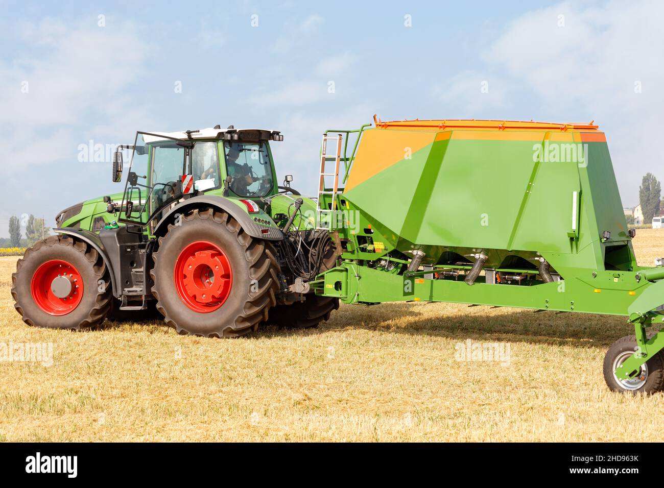 La seminatrice, come unità trainata su un trattore, fornisce un'eccellente preparazione del terreno prima di procedere alla semina sullo sfondo di un campo agricolo raccolto. Foto Stock
