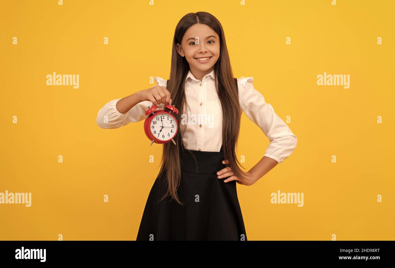 ultima occasione. puntuale teen girl check time. bambino allegro con sveglia. Foto Stock
