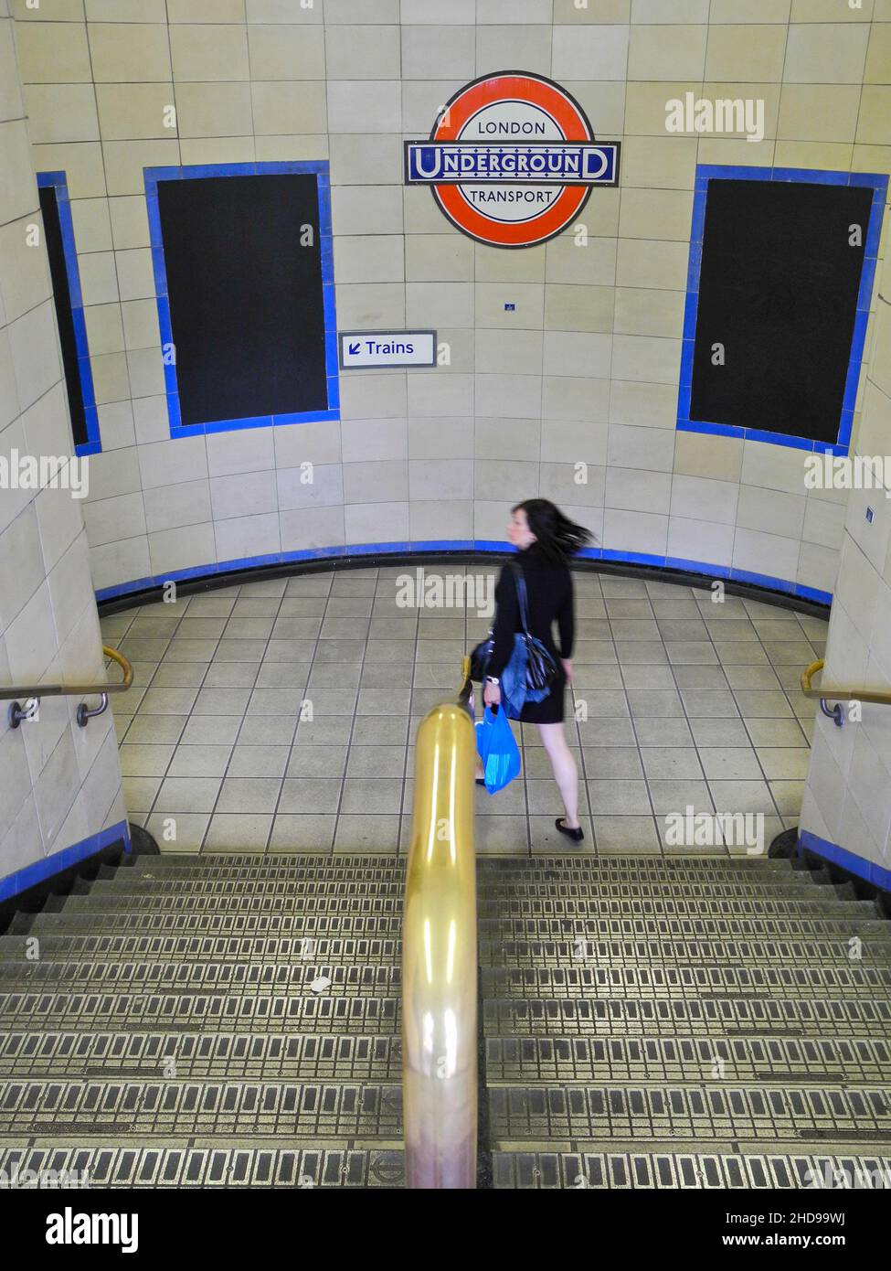 Una giovane donna asiatica si affrettava per il treno alla stazione della metropolitana di Aldgate East sulla metropolitana di Londra. Foto Stock