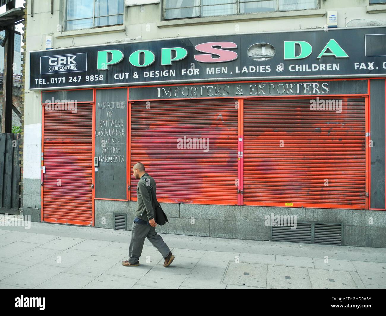 Un uomo asiatico solitario passeggiando Pop Soda, Whitechapel High Street, Aldgate East, Londra, Inghilterra, REGNO UNITO Foto Stock