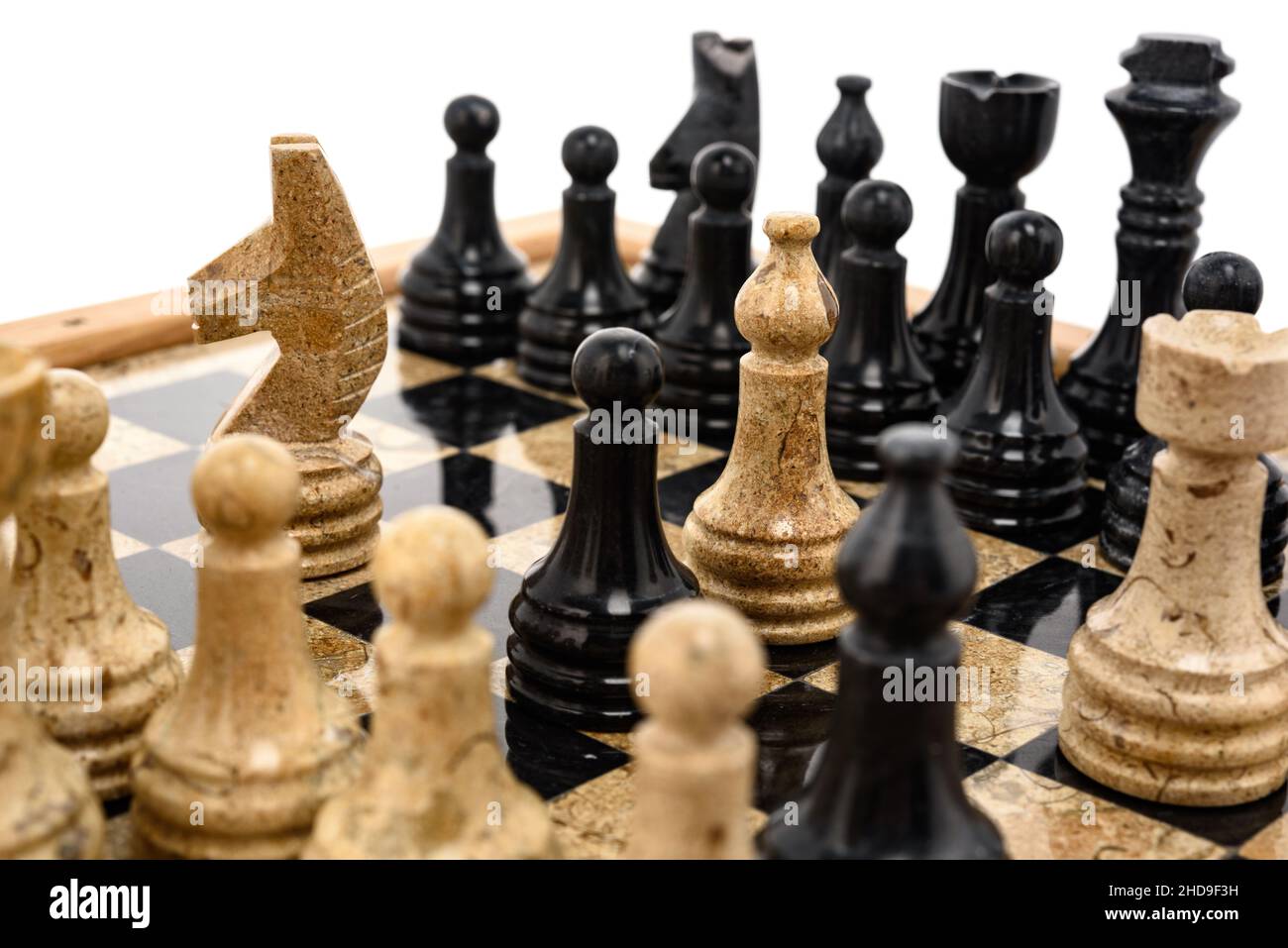 pezzi di scacchi come rivali, al centro su scacchiera in marmo corallo nero e beige. Primo piano del concorso di concetto di gioco, Torneo classico. Foto Stock