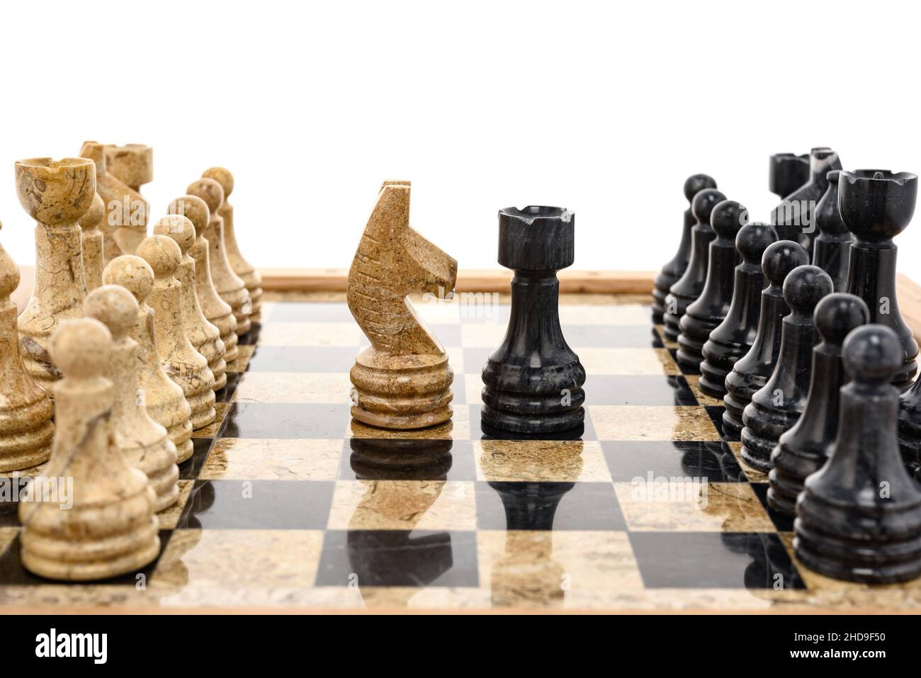 pezzi di scacchi come rivali, al centro su scacchiera in marmo corallo nero e beige. Primo piano del concorso di concetto di gioco, Torneo classico. Foto Stock