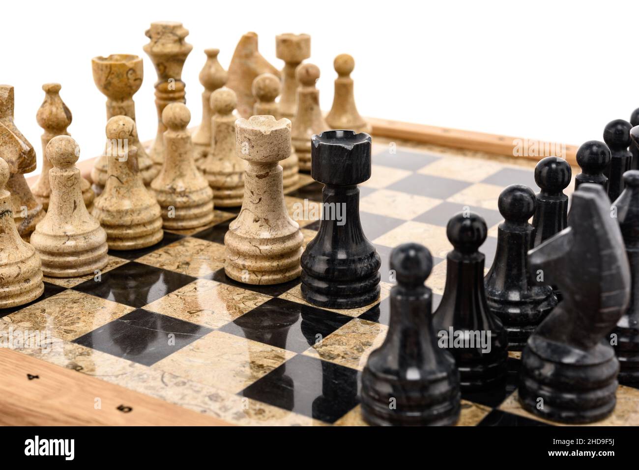 pezzi di scacchi come rivali, al centro su scacchiera in marmo corallo nero e beige. Primo piano del concorso di concetto di gioco, Torneo classico. Foto Stock