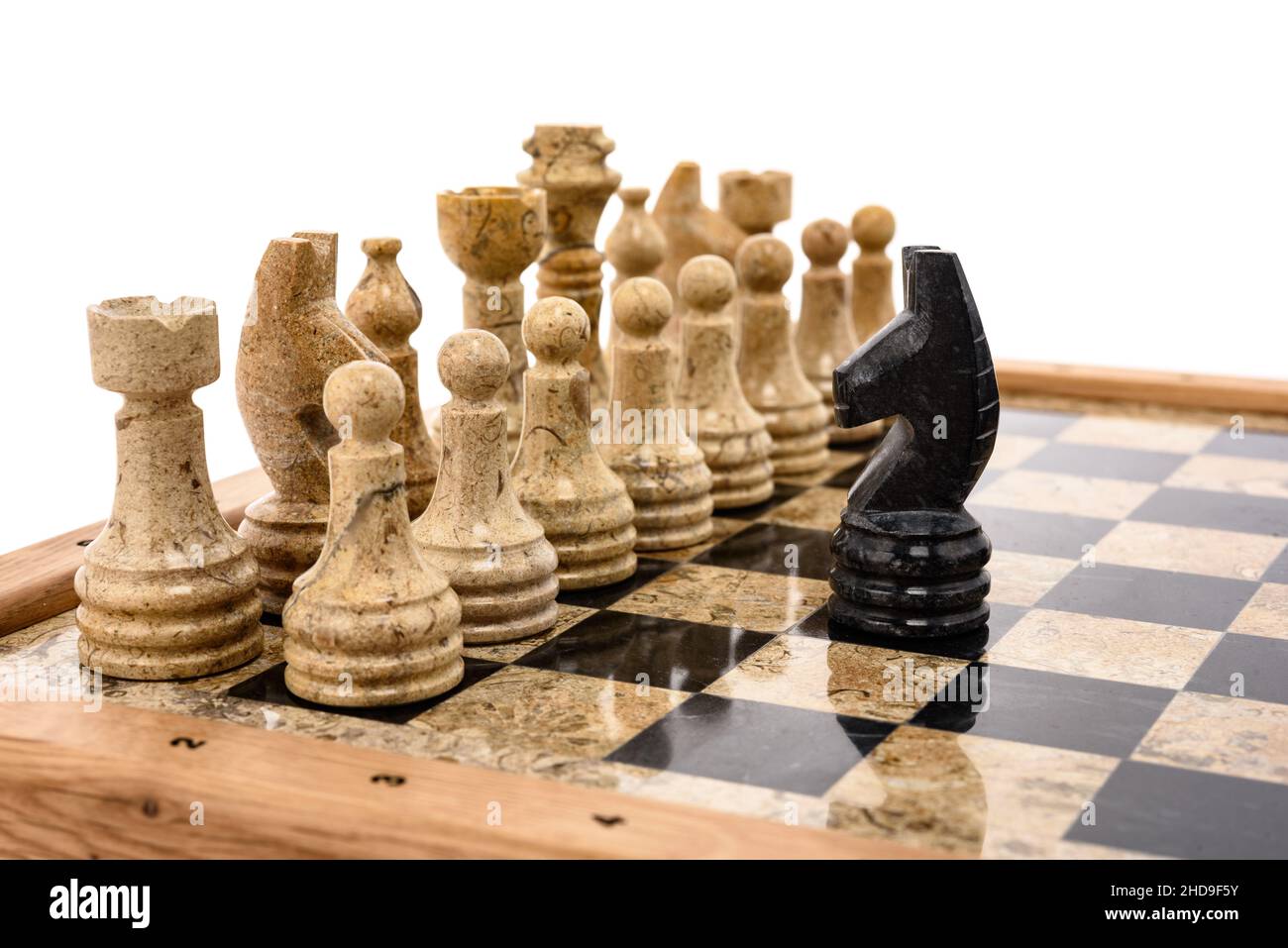 pezzi di scacchi come rivali, al centro su scacchiera in marmo corallo nero e beige. Primo piano del concorso di concetto di gioco, Torneo classico. Foto Stock