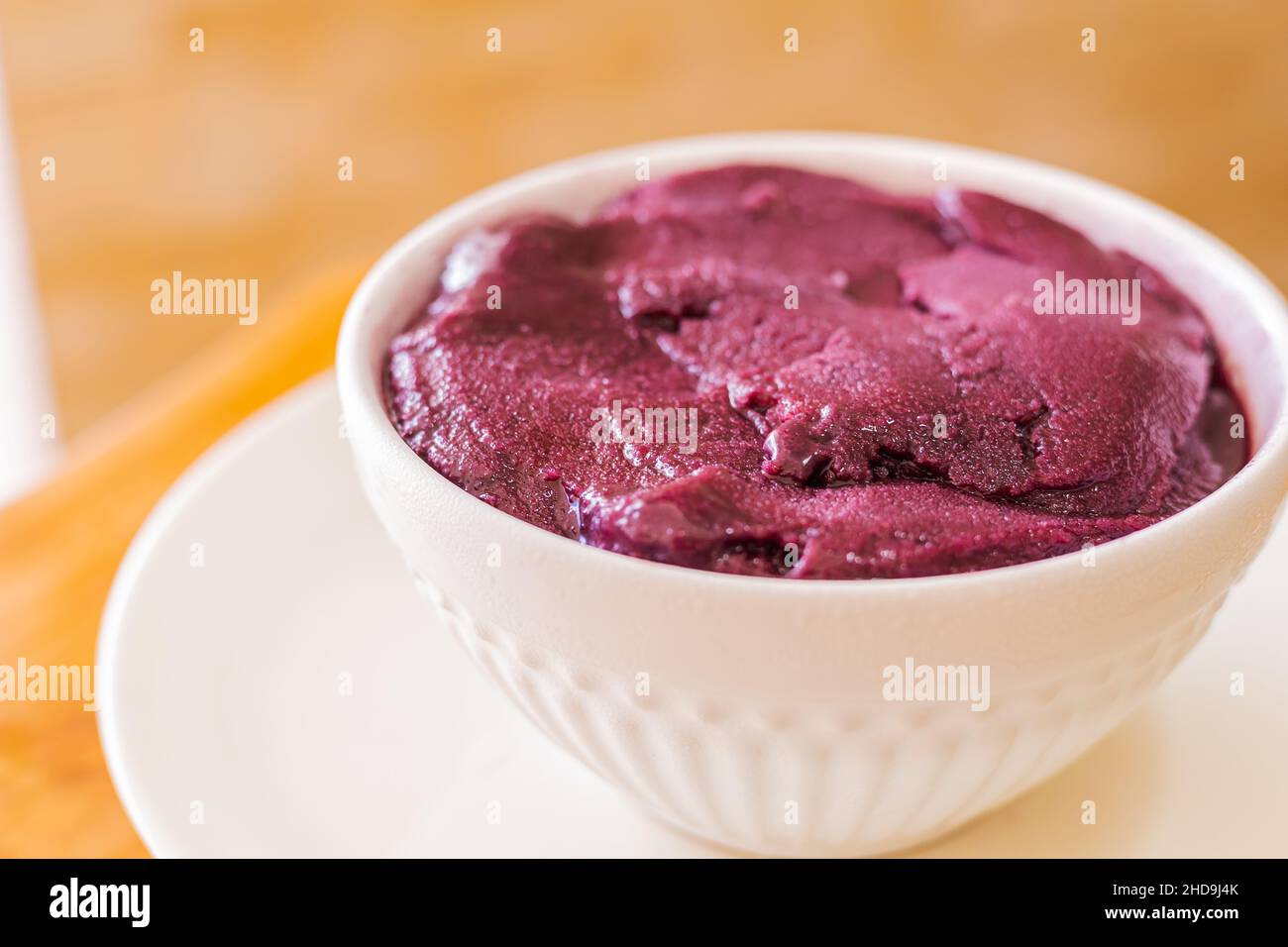 congelato açaí servito in ciotola bianca su sfondo di legno. Cucina brasiliana. Foto Stock