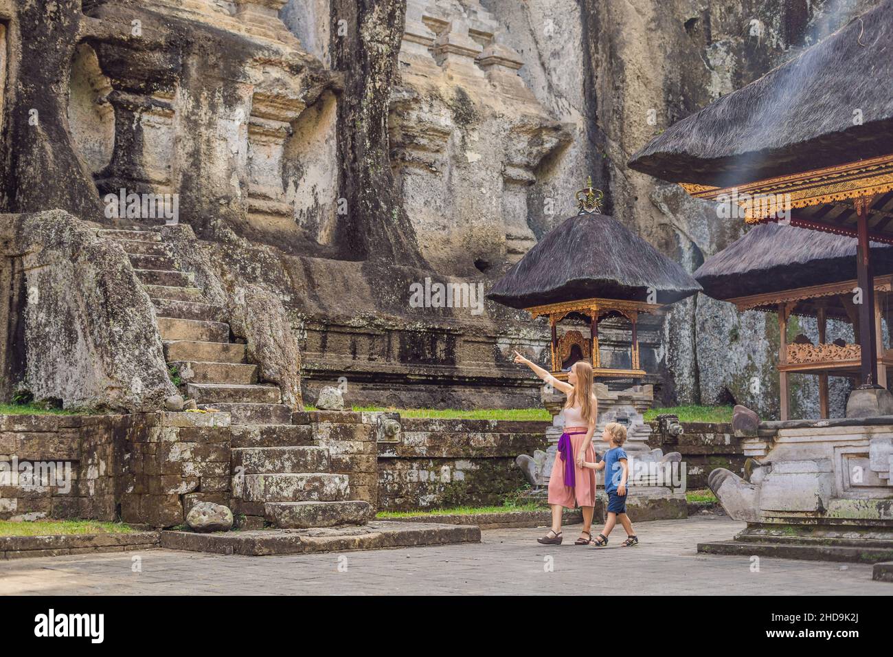 Mamma e figlio su sfondo di Gunung Kawi. Antico scolpito nel tempio in pietra con tombe reali. Bali, Indonesia. Concetto di viaggio con bambini Foto Stock