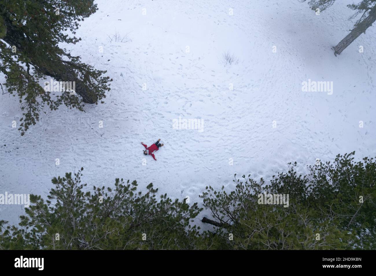 L'antenna drone di donna che indossa abiti caldi si sdraia sulla neve in inverno. Troodos cipro Foto Stock
