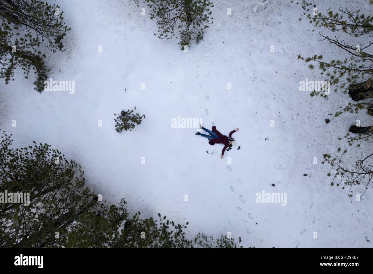 L'antenna drone di donna che indossa abiti caldi si sdraia sulla neve in inverno. Troodos cipro Foto Stock