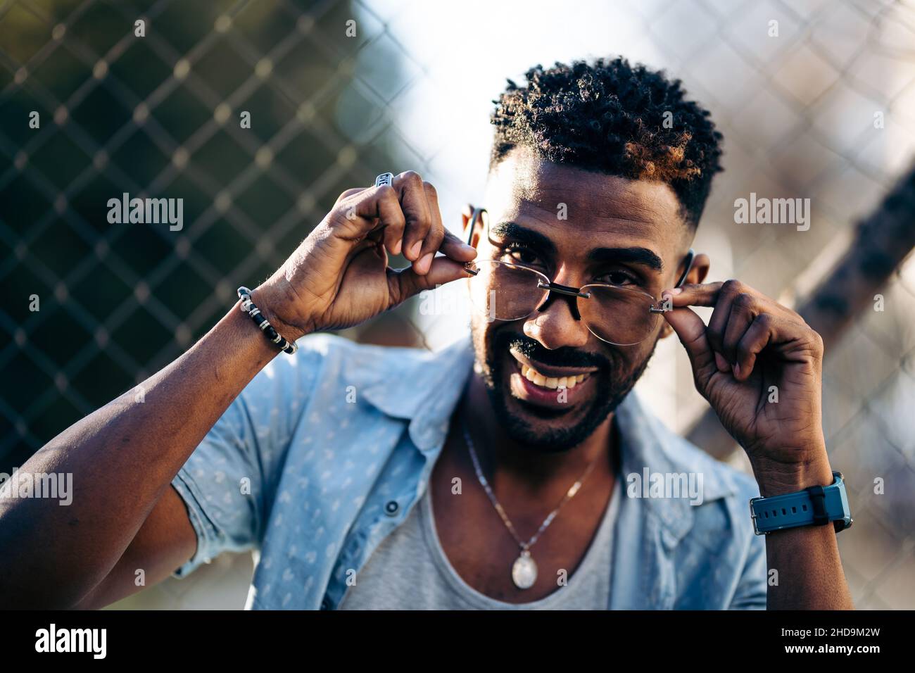 Ritratto di un uomo afroamericano che guarda la macchina fotografica sopra i suoi occhiali sorridendo Foto Stock