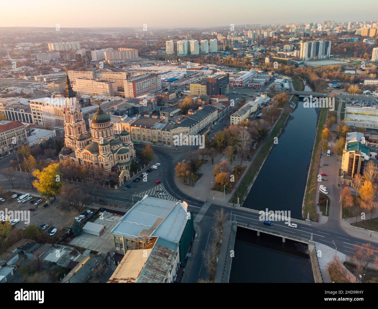 Cattedrale dell'Annunciazione al tramonto. Veduta aerea vicino al lungofiume di Lopan a Kharkiv, Ucraina. Paesaggio urbano autunnale, strade della città Foto Stock