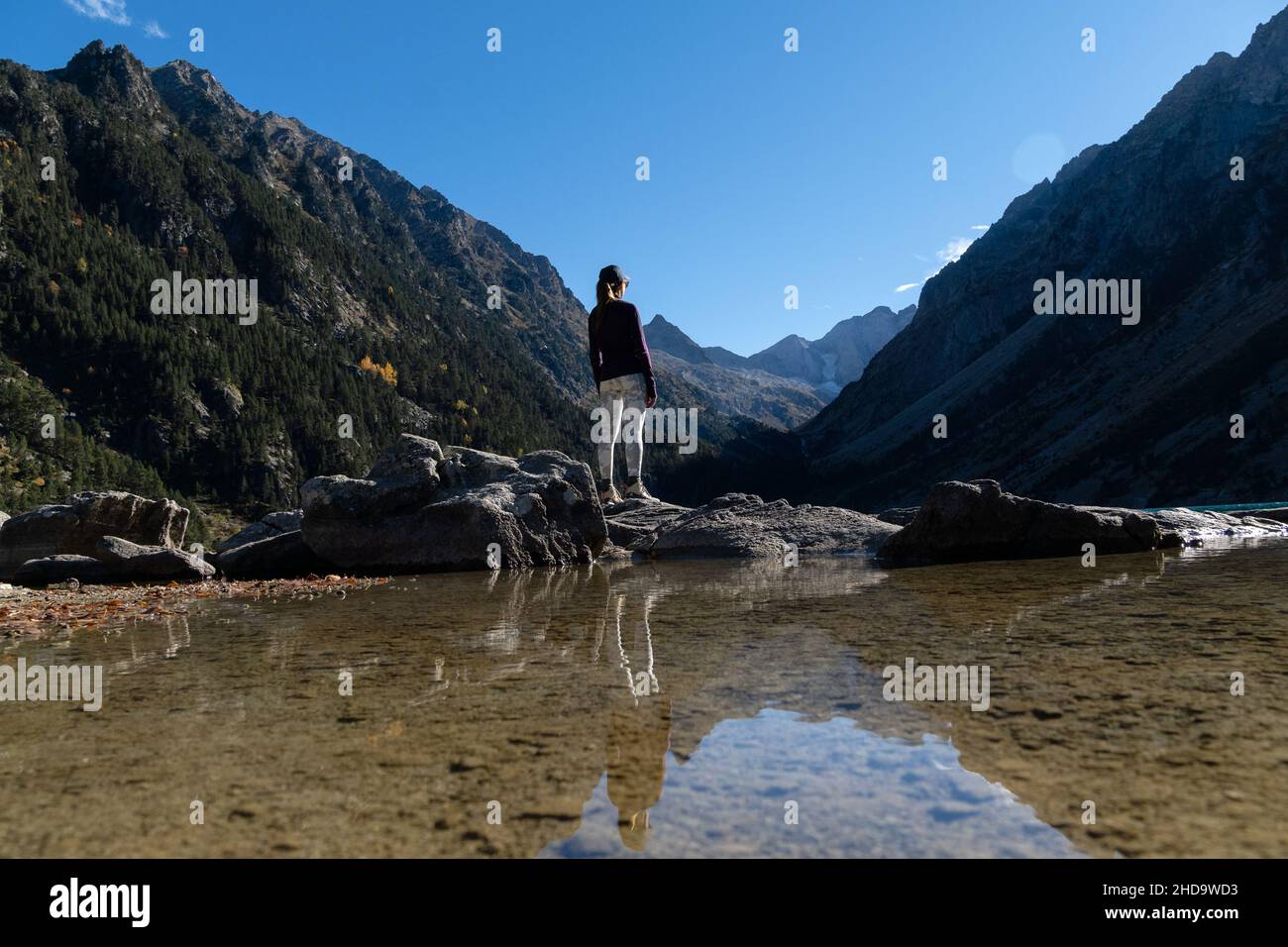 Giovane donna viaggiatore in piedi sulle rocce sulla riva del Lac de Gaube Foto Stock