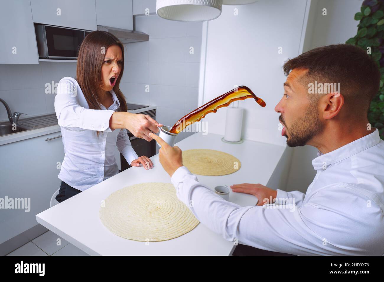 Giovane coppia litigando. Problemi di relazione. La donna arrabbiata lancia il caffè in mans Face. Foto Stock
