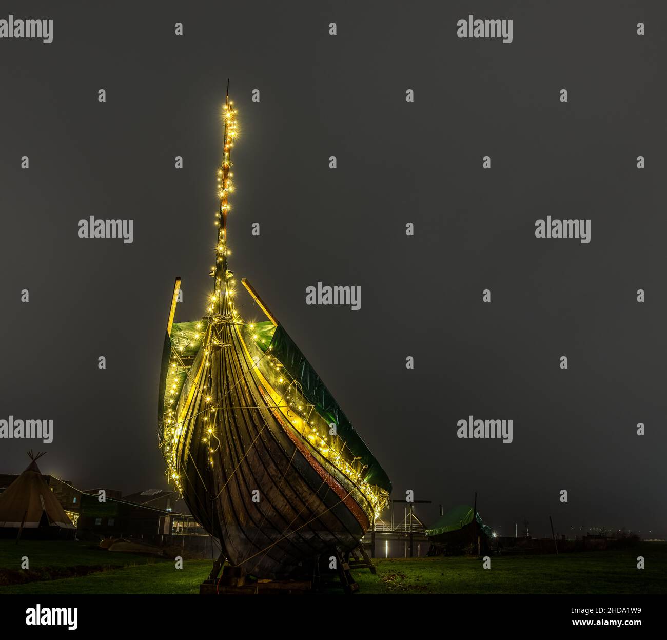 Nave vichinga con luci di Natale accese di notte su un prato nel porto di Roskilde, Danimarca, 1 gennaio 2022 Foto Stock