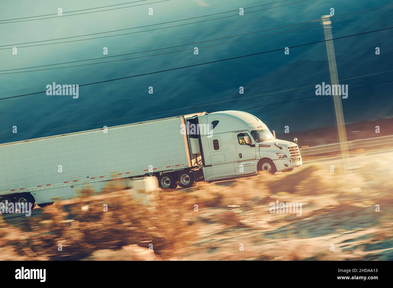 Veicolo semi-rimorchio moderno in accelerazione su una Desert Highway nella California meridionale. Tema del trasporto. Foto Stock