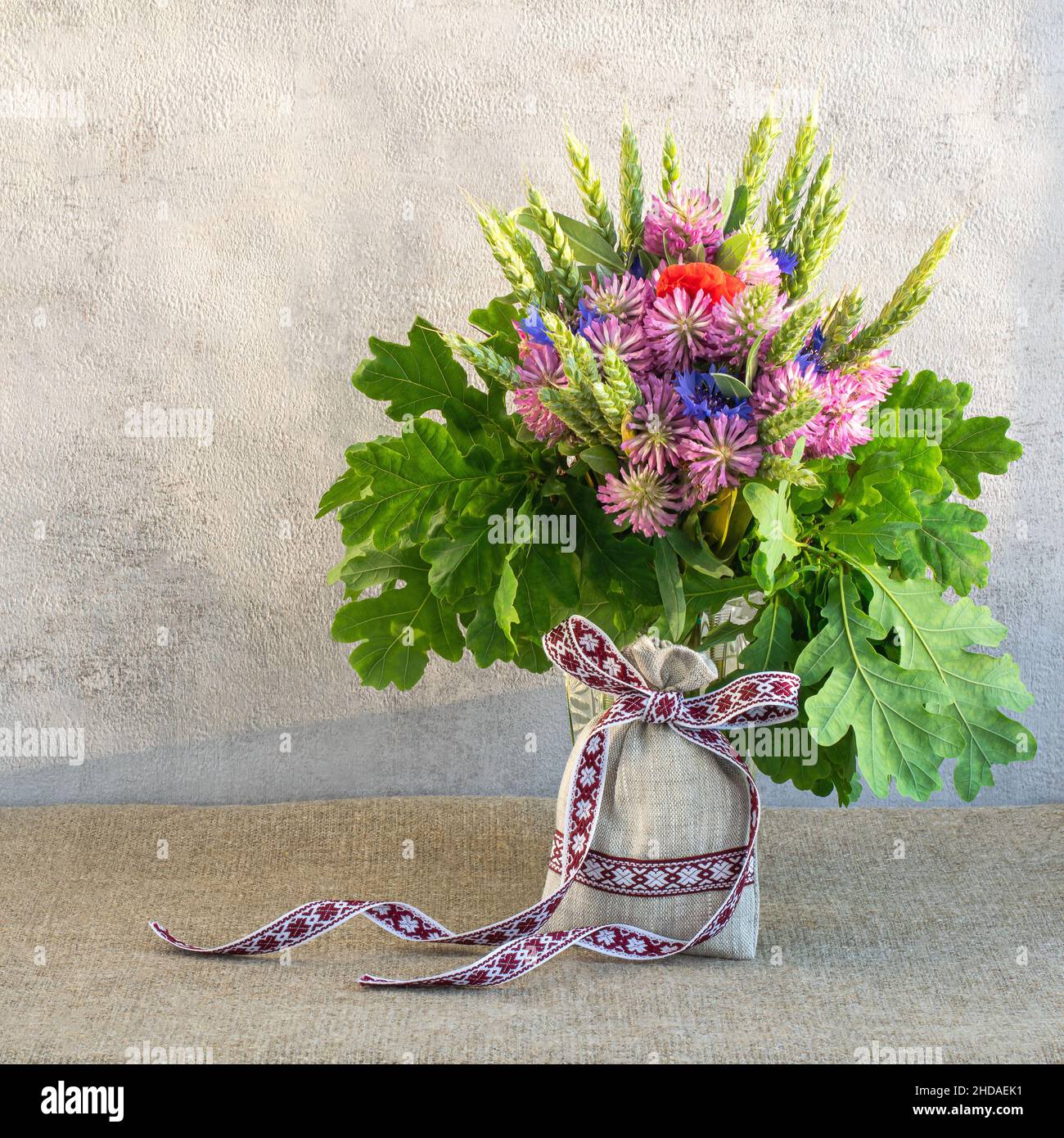 Allestimento fiori estivi per vacanze nazionali lettoni su sfondo chiaro, formato quadrato Foto Stock