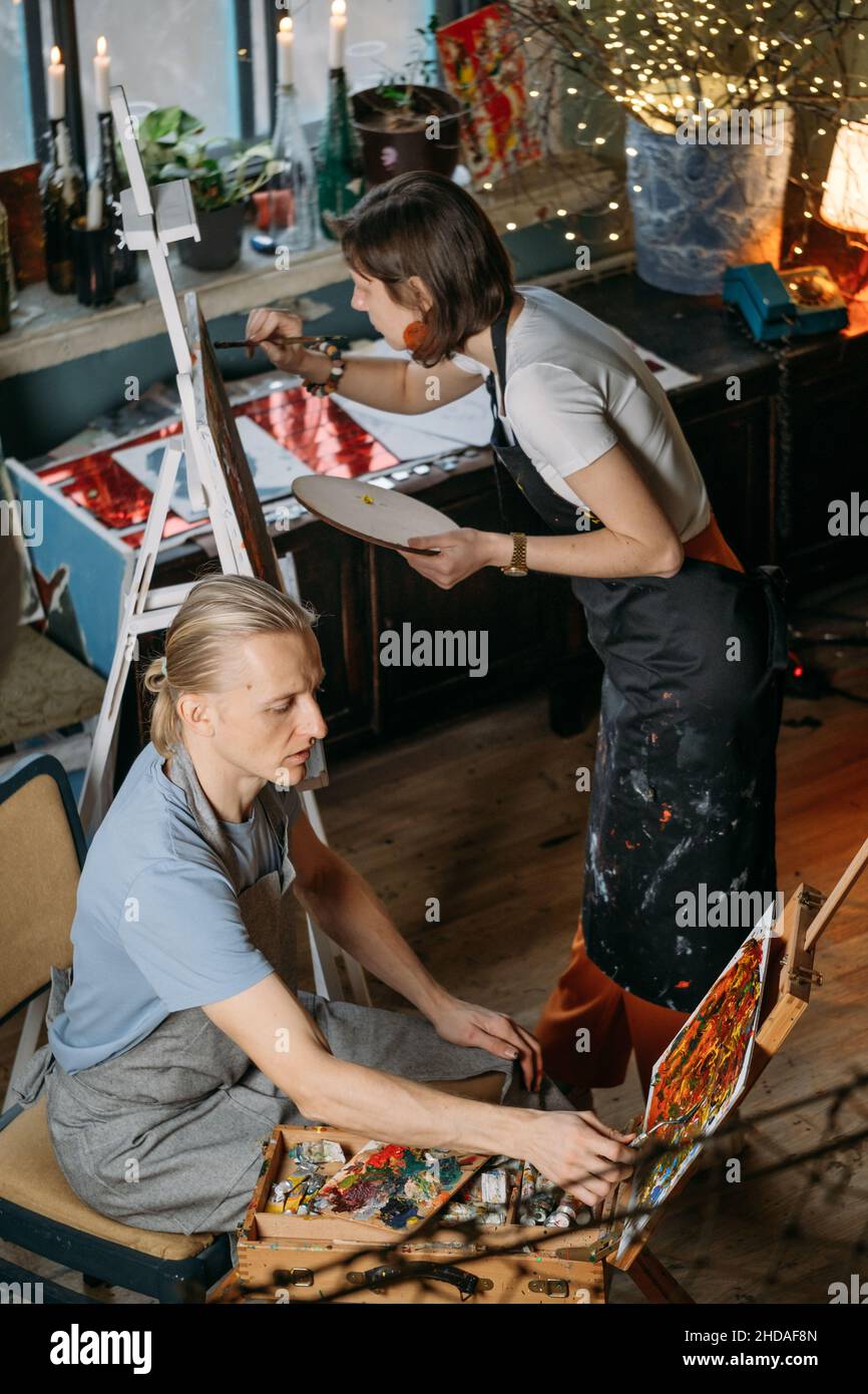 Gruppo creativo laboratorio di pittura su tela grande in studio. Studenti di pittura a lezioni d'arte. Educazione artistica per adulti. Hobby e lavoro Foto Stock