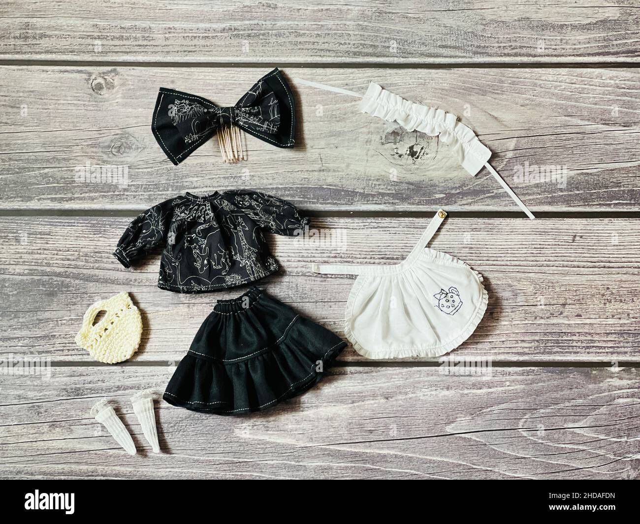 Vista dall'alto dei costumi e degli accessori di bambola su un tavolo di legno Foto Stock