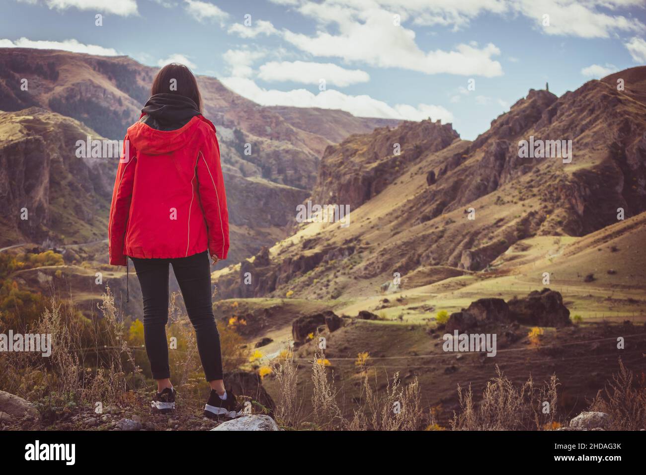 La donna si erge sul bordo e ammira la sacape drammatica del caucaso a Vardzia. Georgia. Libertà di movimento e blogging di viaggio. Foto Stock