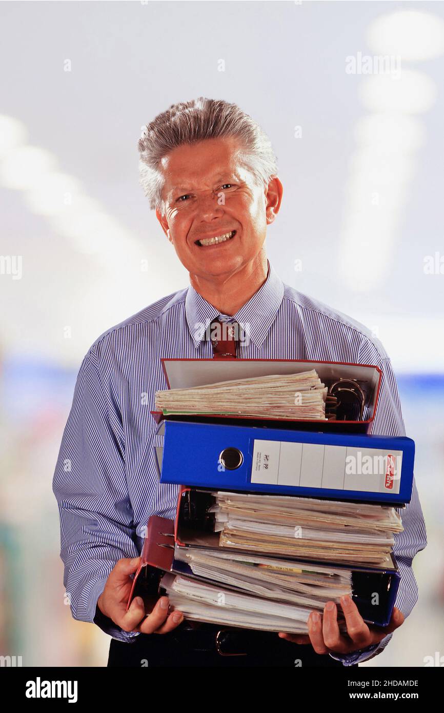 Mann, Senior, Angestellter, Rechtsanwalt, Büro, trägt einen Stapel Aktenordner Foto Stock