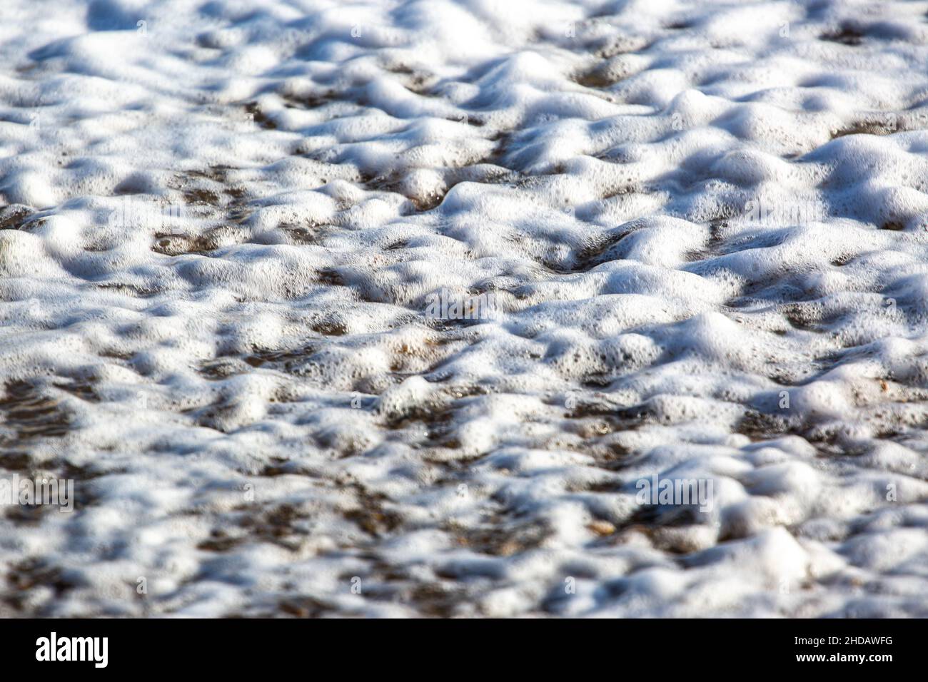 Mentre le onde si infrangono su una spiaggia di Suffolk Foto Stock