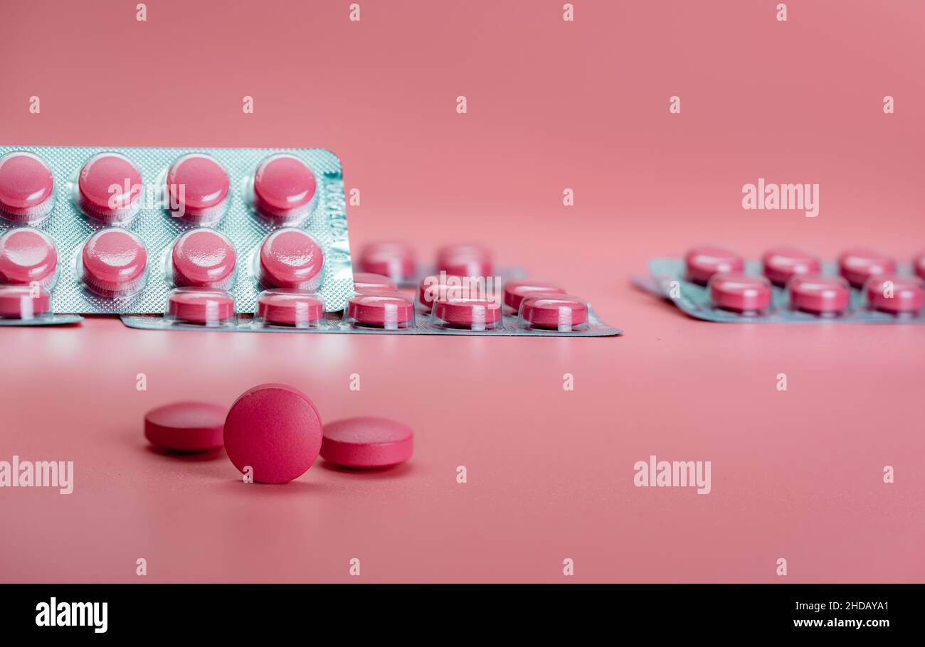 Compresse rosa e blister su sfondo rosa. Farmaco da prescrizione. Vitamine, minerali e supplementi concetto. Farmaceutico Foto Stock