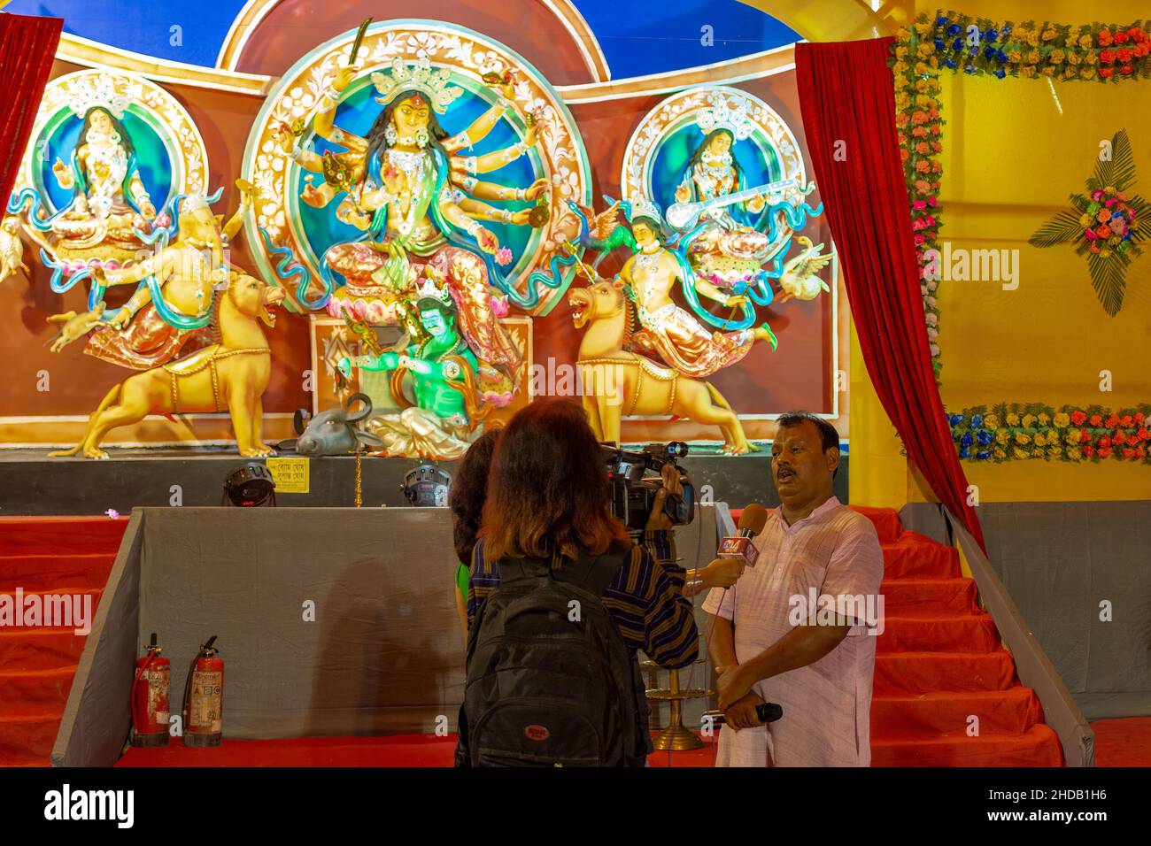 Membro del comitato di Durga Puja che dà un'intervista al canale locale di notizie tv circa la loro puja Foto Stock