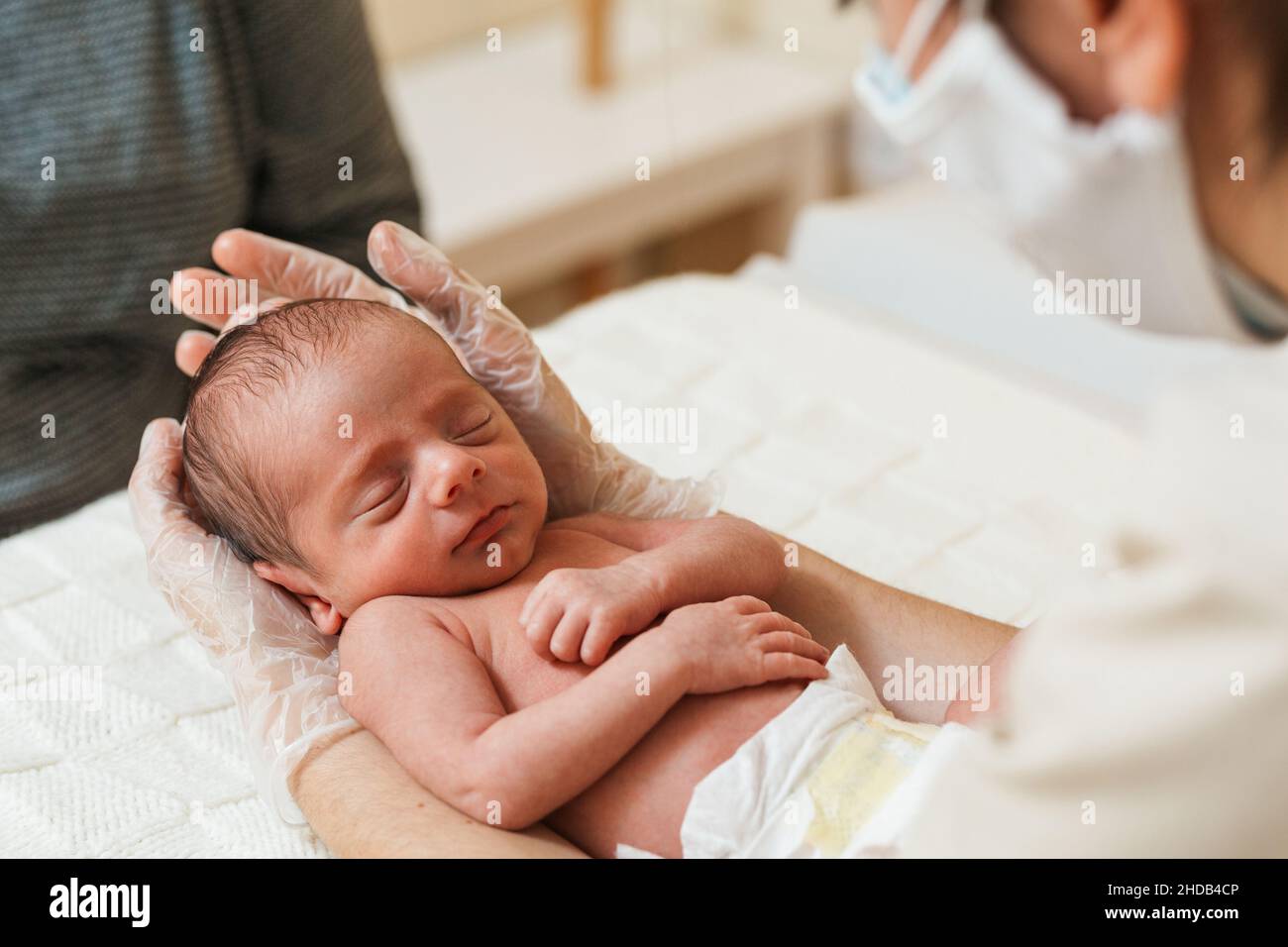 Vista ravvicinata di un medico fisioterapista che tiene un neonato. Foto Stock