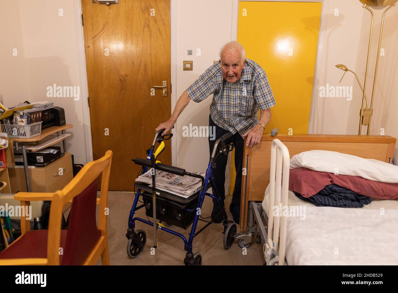 Pensionato di vecchiaia alla fine degli anni '80 che vive da solo con i suoi effetti personali nella sua stanza in una casa di cura residenziale in Inghilterra, Regno Unito Foto Stock