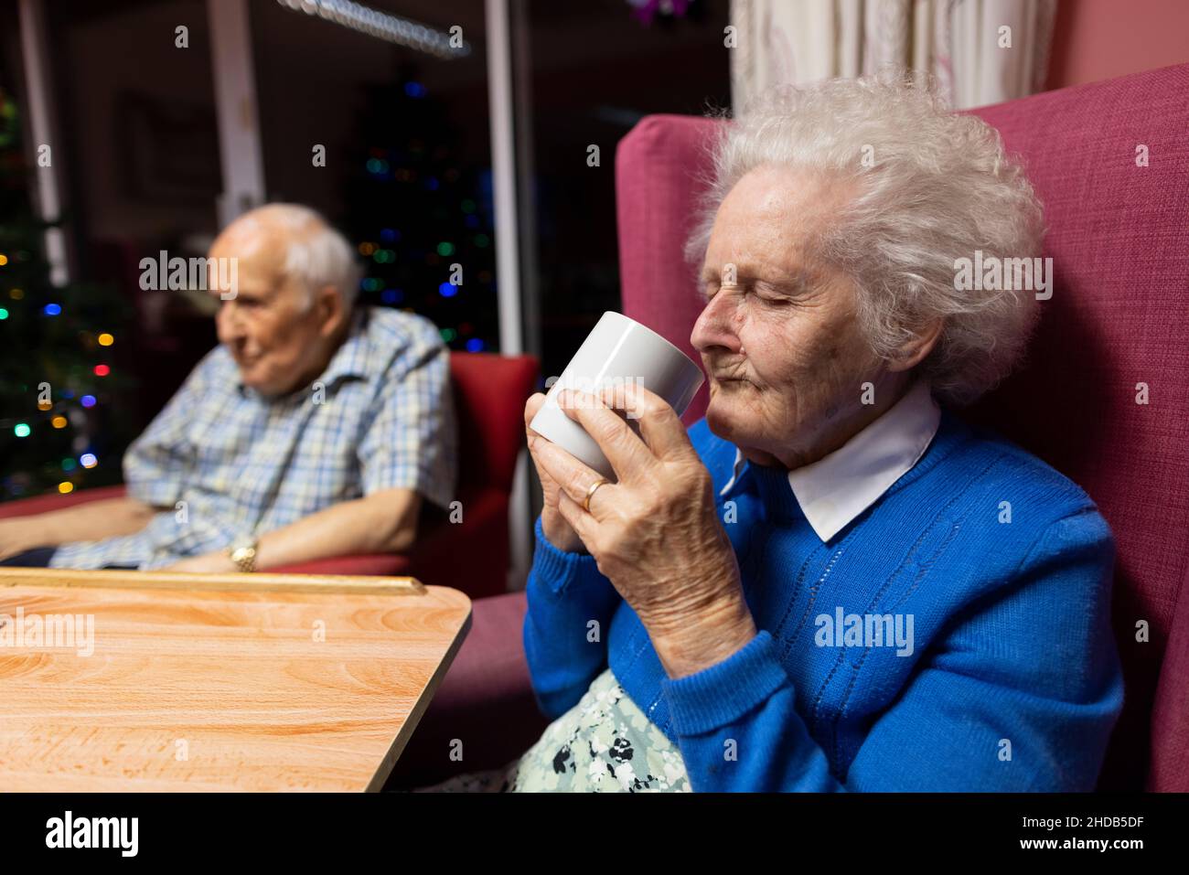 Coppie anziane negli anni ottanta seduti insieme nella loro casa di cura residenziale, Inghilterra, Regno Unito Foto Stock