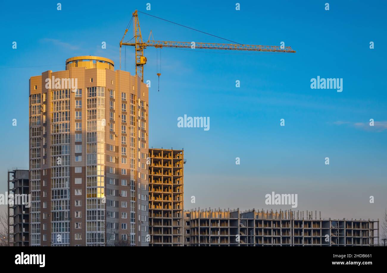vista di un edificio non residenziale incompiuto con un'alta gru Foto Stock