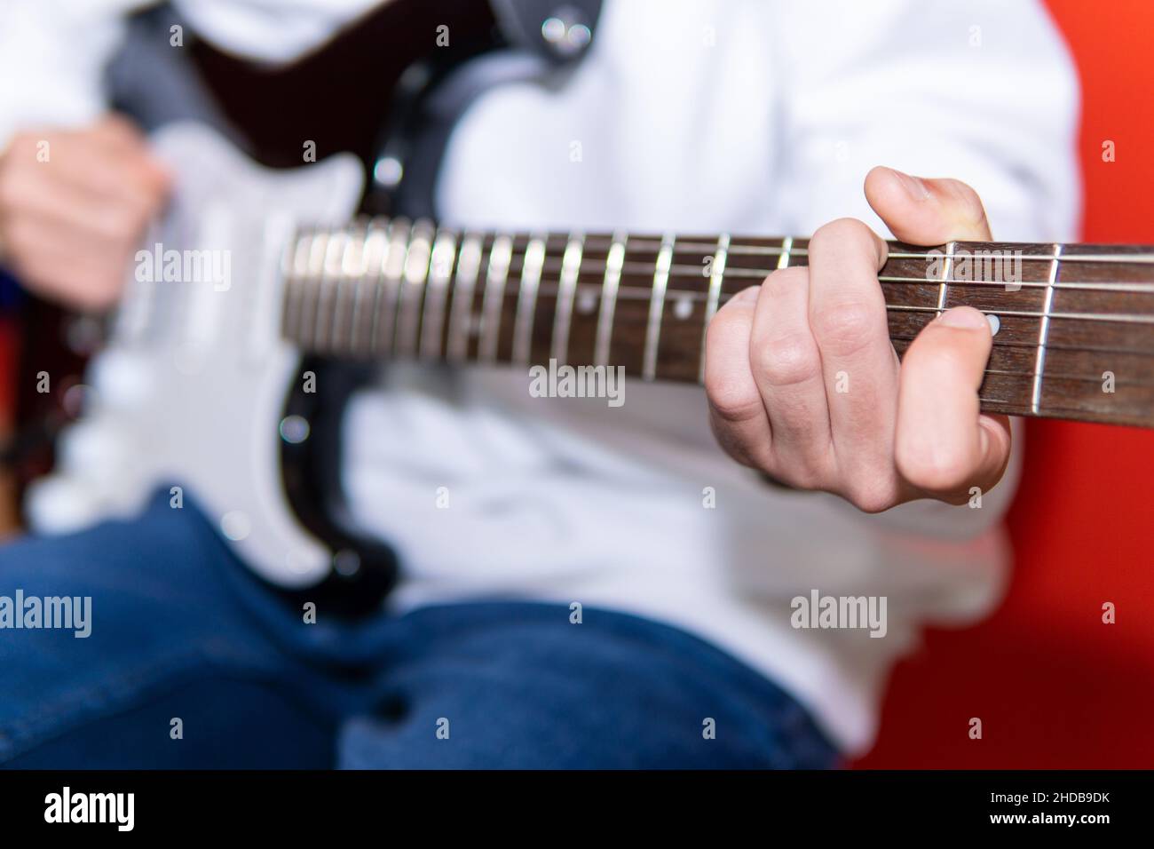 Giovane uomo irriconoscibile che suona la chitarra elettrica. Musica, educazione degli strumenti, intrattenimento, rock star, concerto musicale e concetto di apprendimento Foto Stock