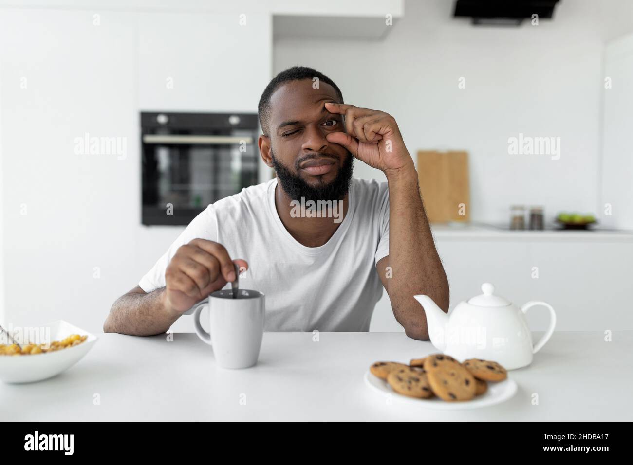 Uomo nero che soffre di insonnia bere caffè Foto Stock