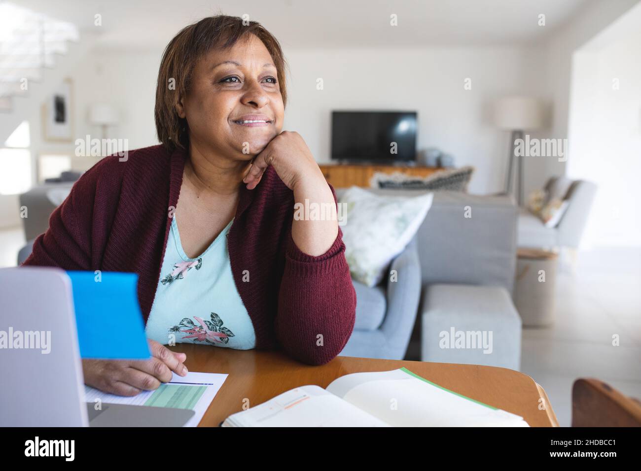 Donna anziana premurosa con laptop durante la consultazione del medico in linea a casa Foto Stock