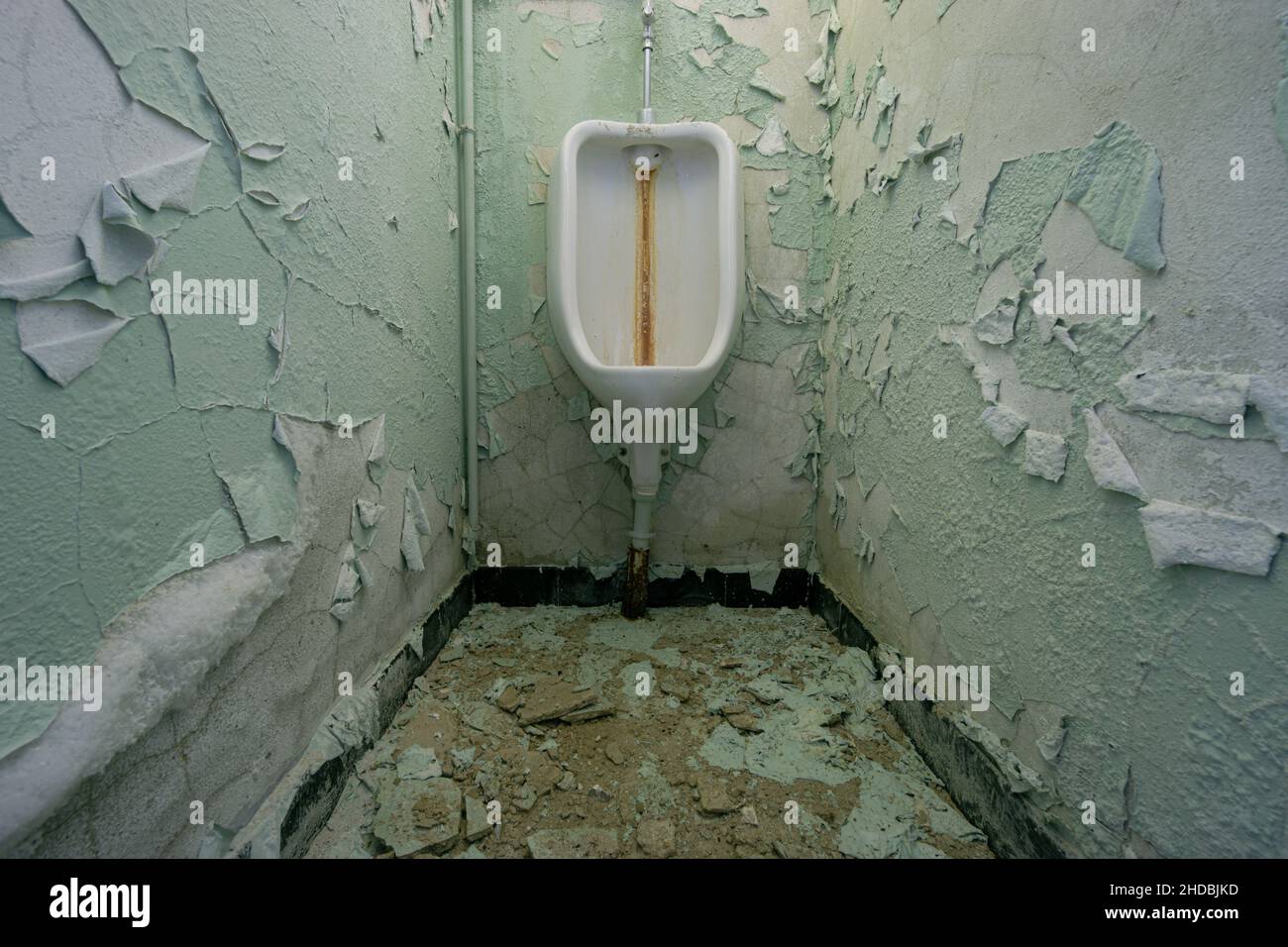 Vecchio bagno sporco disgustoso per gli uomini con pareti grungy intemperie incrinate Foto Stock