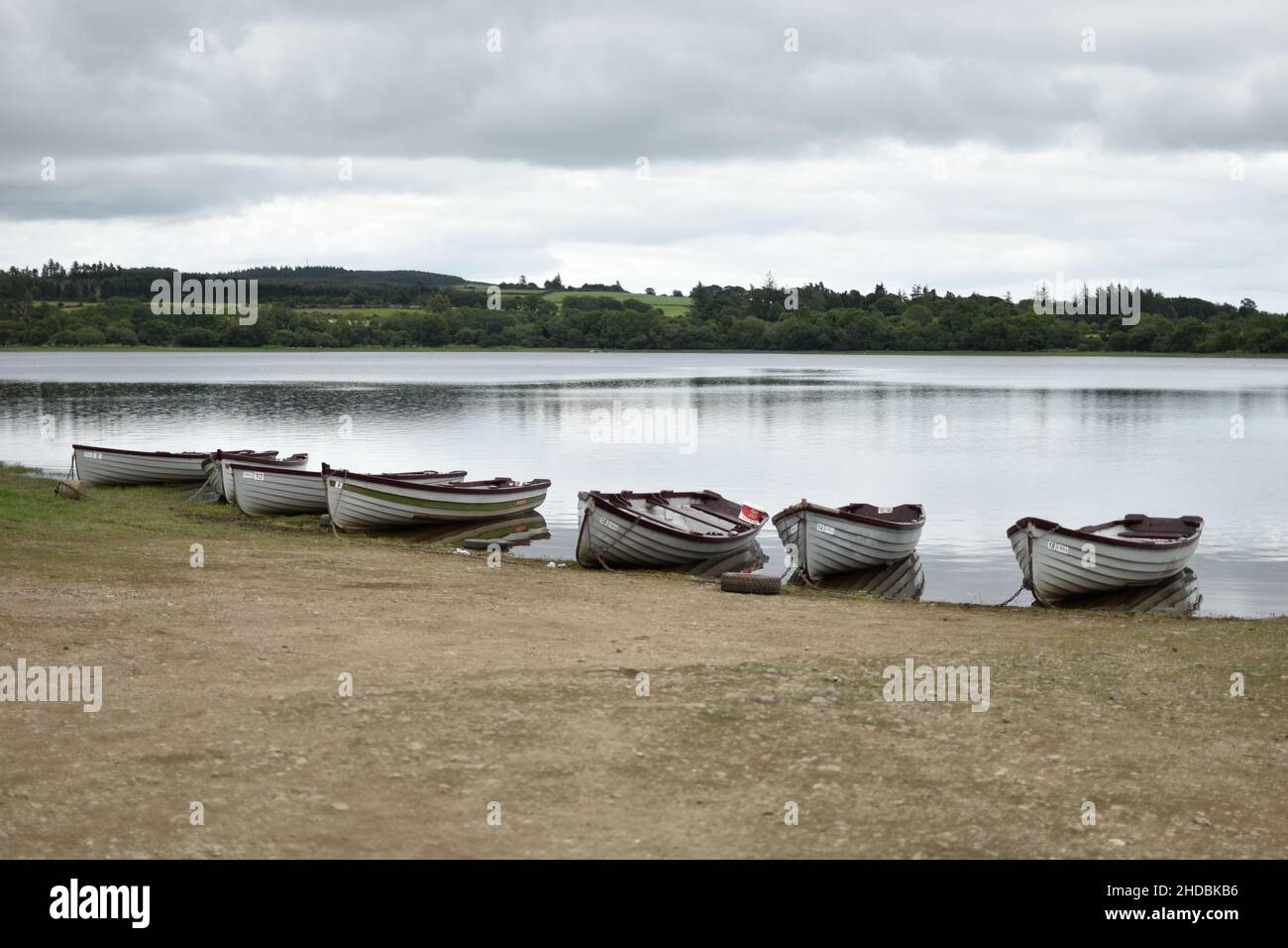 Primo piano di barche a remi in legno su un lago in una giornata nuvolosa Foto Stock