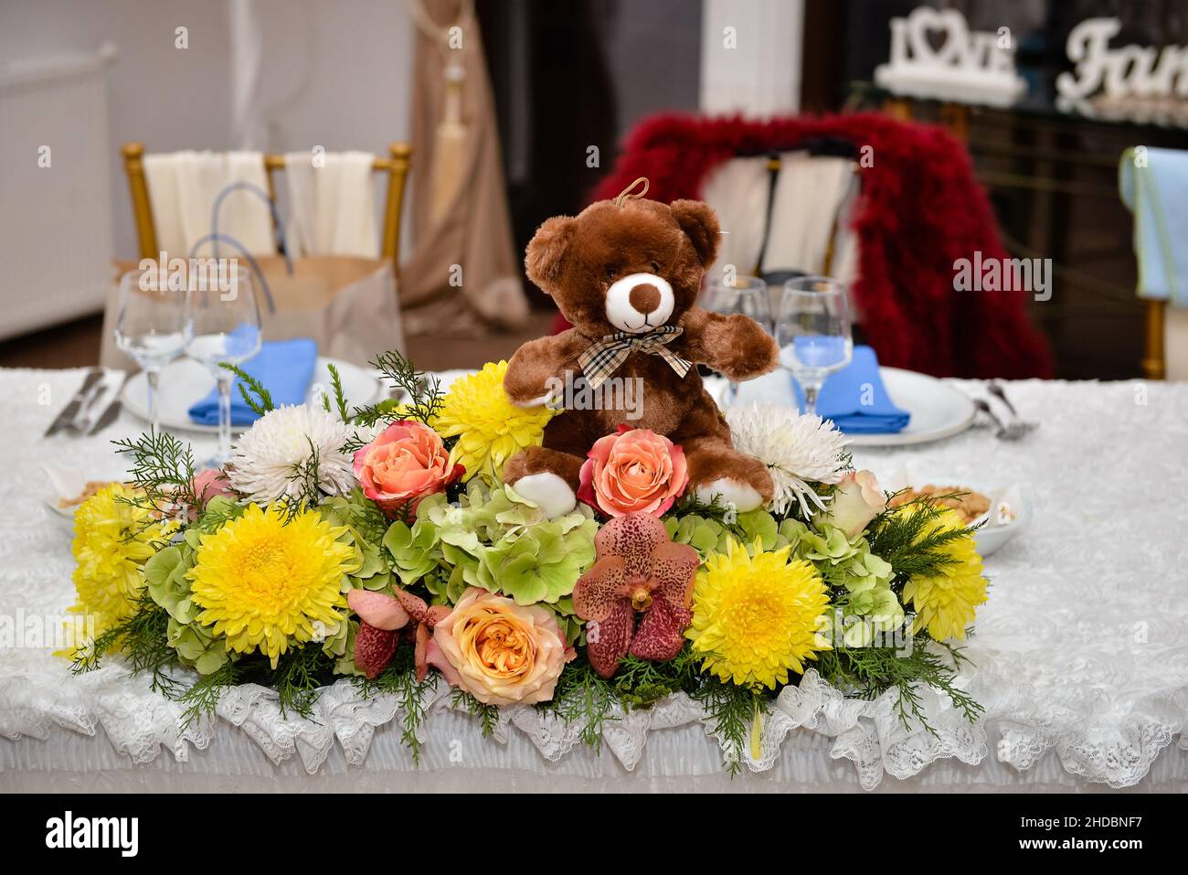Primo piano di un bellissimo arrangiamento floreale e un orsacchiotto in una celebrazione di debutto Foto Stock