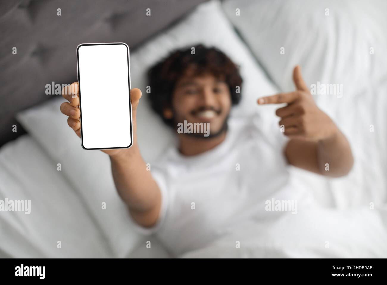 Uomo indiano che punta allo smartphone con schermo vuoto Foto Stock