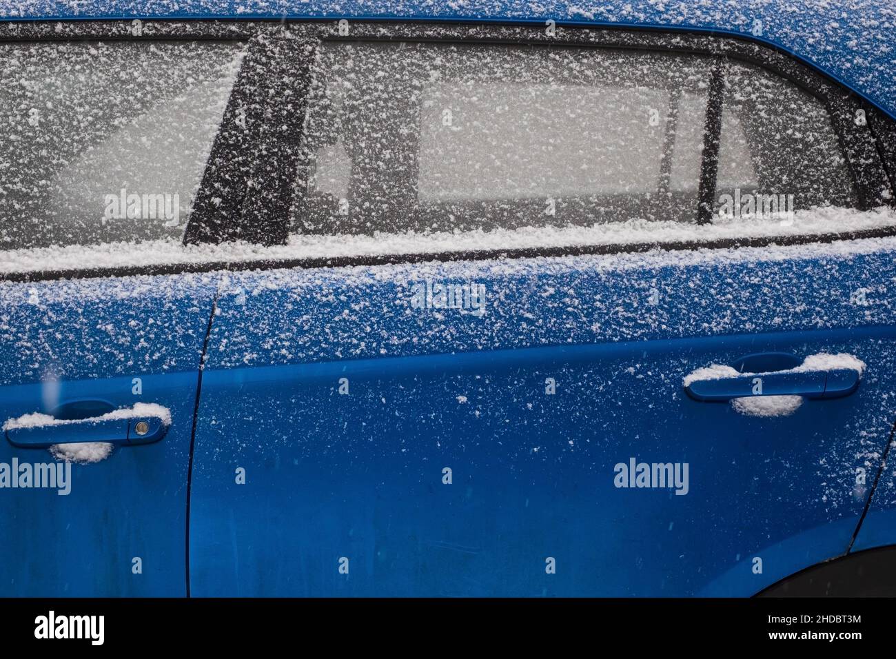 Parabrezza per auto ghiacciato coperto di ghiaccio e neve in una giornata invernale. Foto Stock