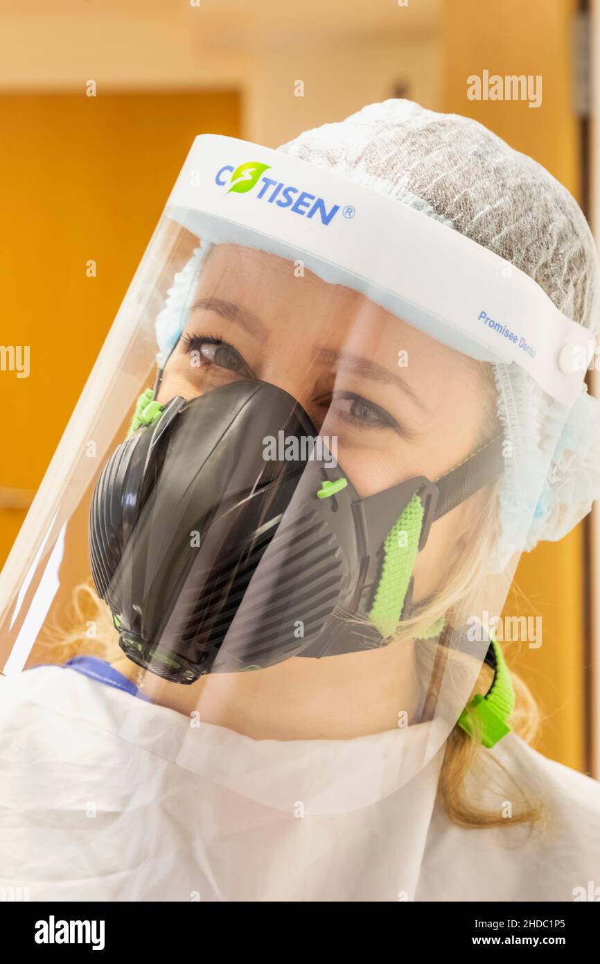 Inghilterra, Ritratto di un'infermiera femminile Pretty che indossa la maschera di protezione Covid PPE Foto Stock