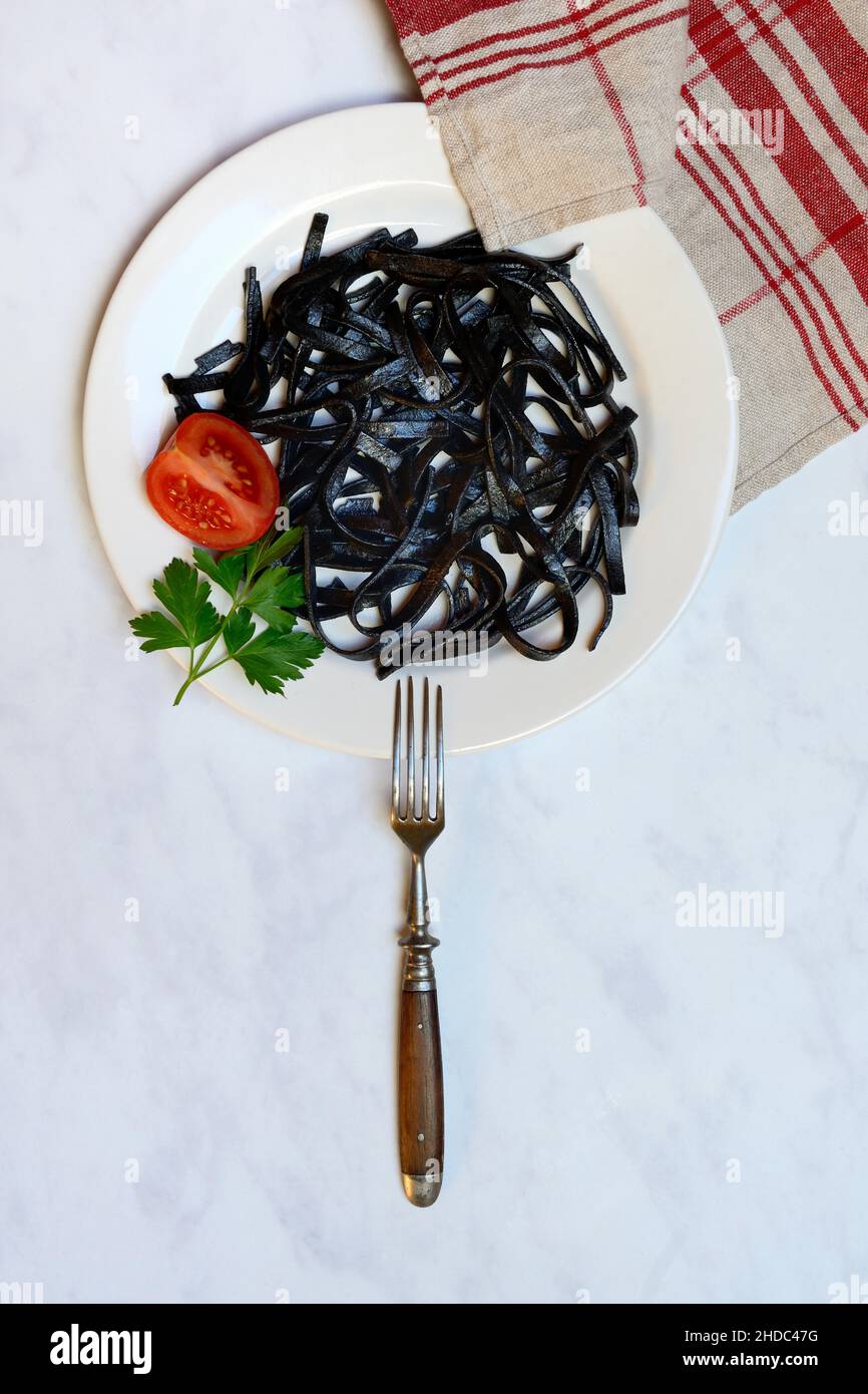 Pasta nera con inchiostro calamaro sul piatto, Tagliolini al Nero di Seppia, Italia Foto Stock