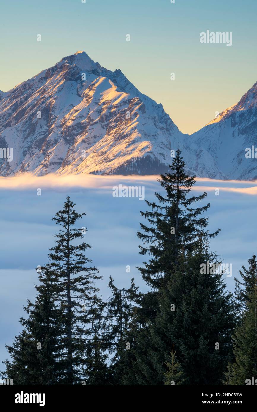 Paesaggio montano invernale con copertura della nebbia chiusa sulla valle dell'Inn, sullo sfondo la catena Gleirsch-Halltal delle montagne del Karwendel, visto da Foto Stock