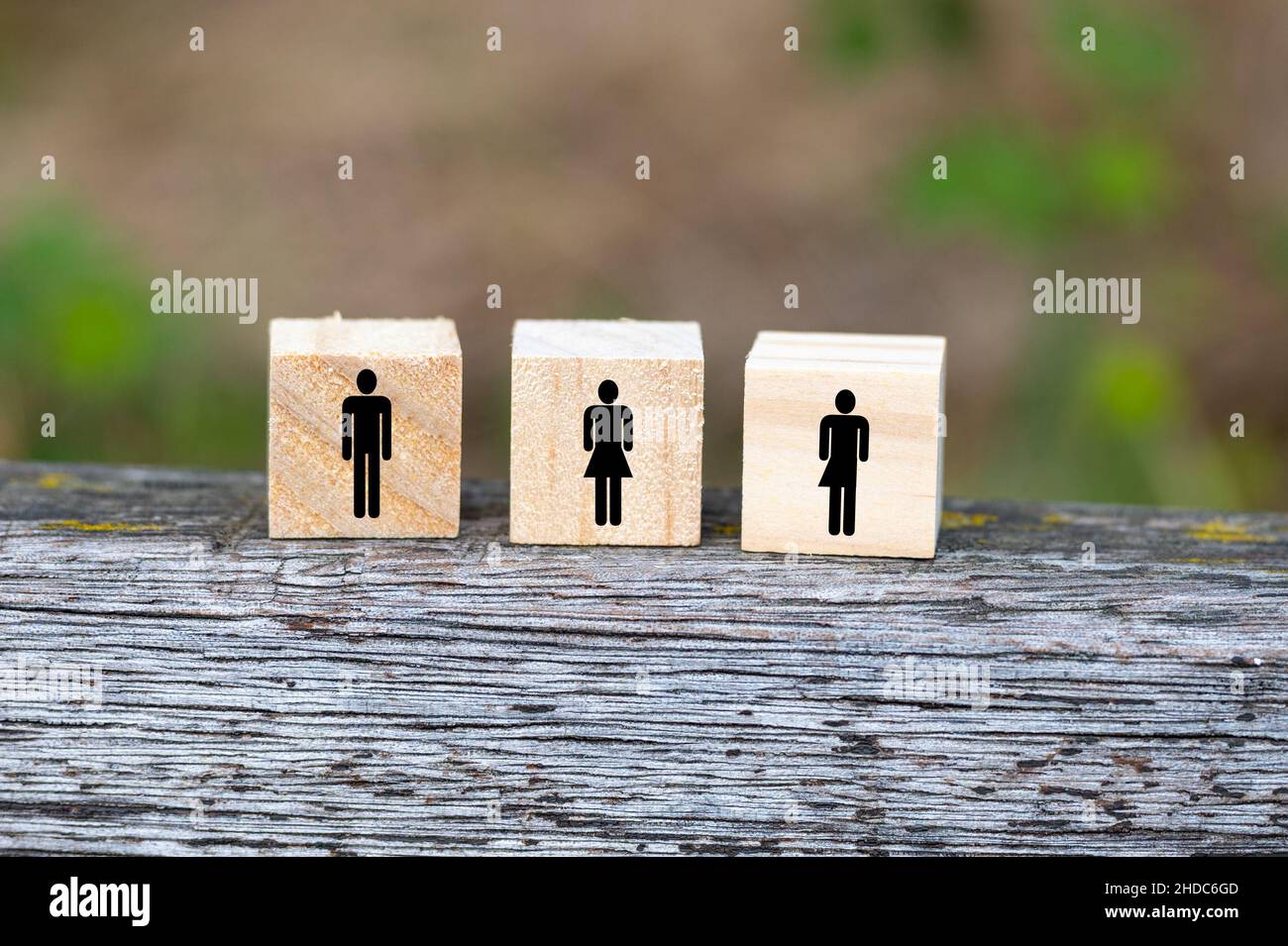 Messa a fuoco superficiale di blocchi di legno per tre persone su un tavolo di legno con sfondo sfocato Foto Stock