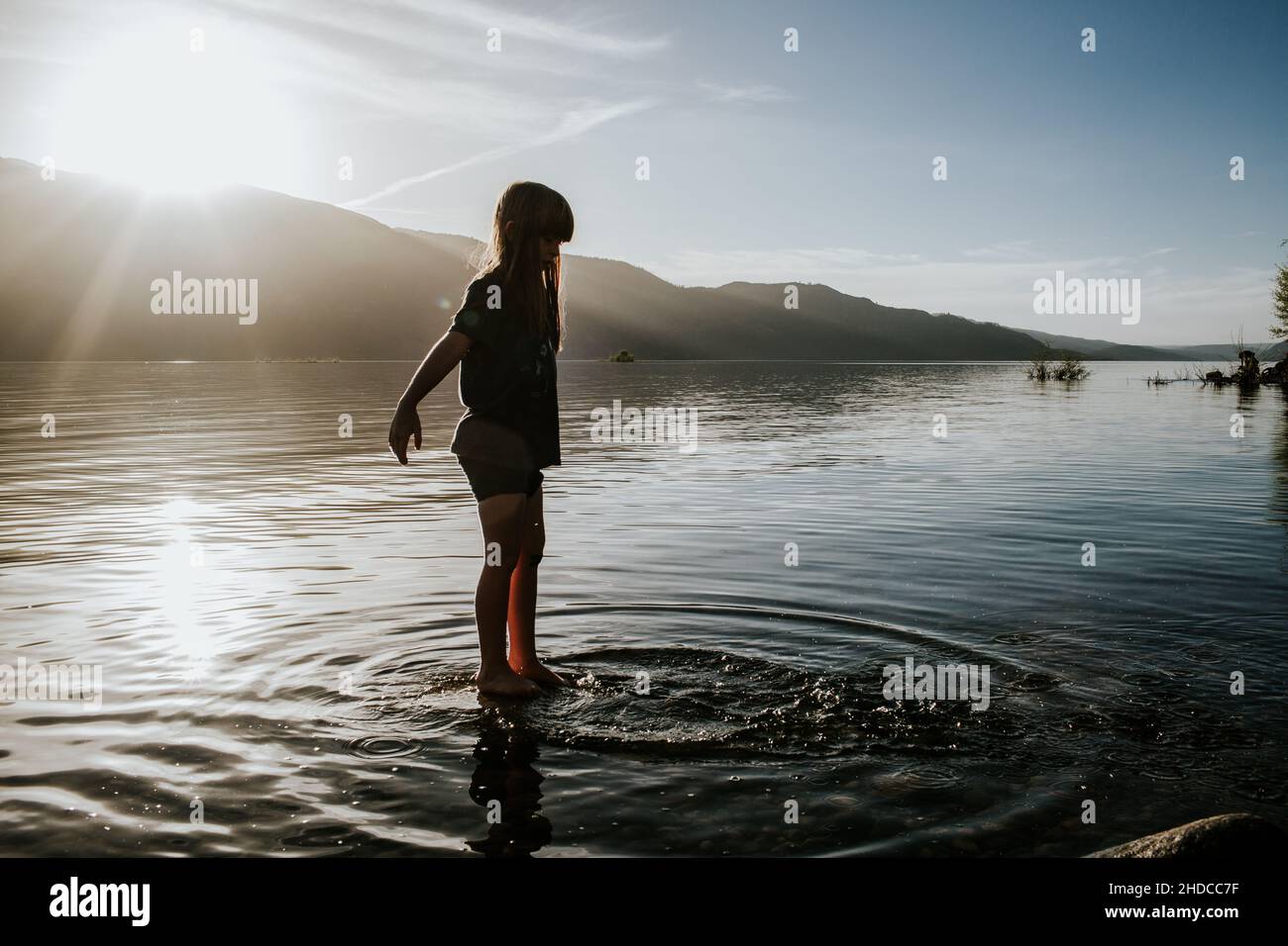 Giovane ragazza che si tuffa in un lago in una giornata di sole Foto Stock