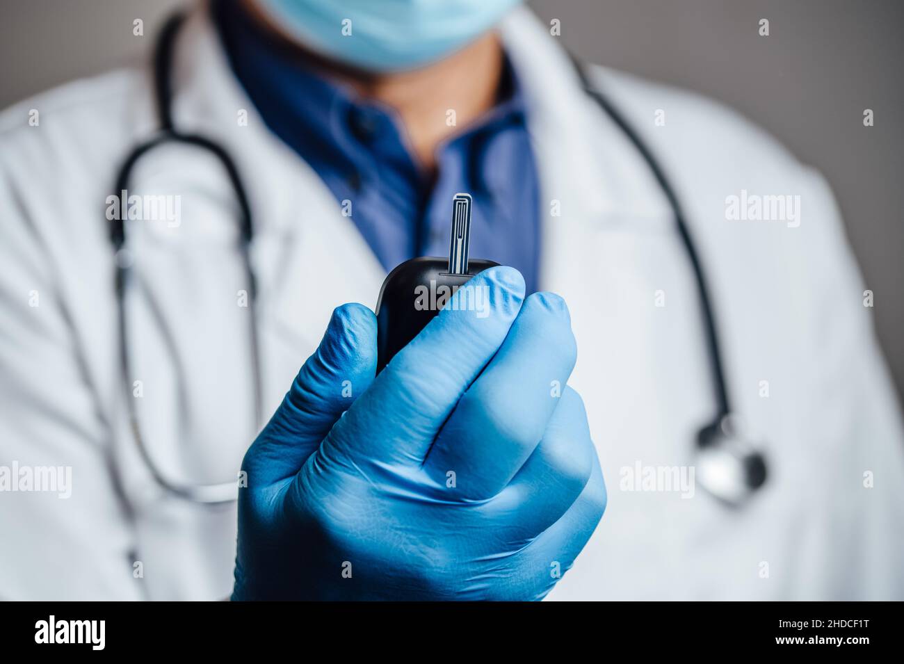 Medico che tiene un controllo della glicemia Foto Stock