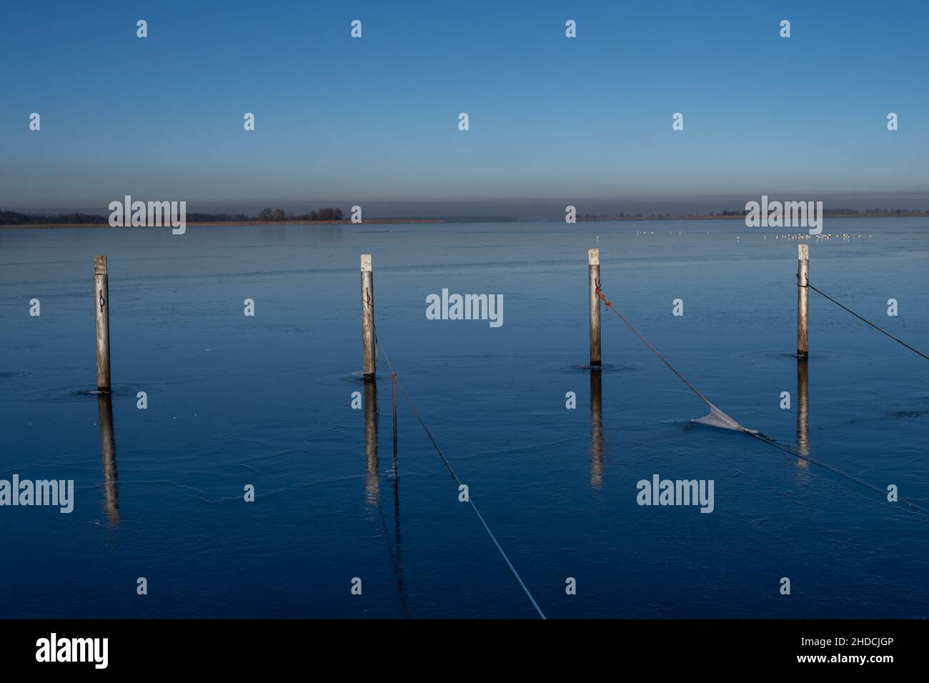 Una vista di banchine vuote in inverno. Acqua blu e cielo blu chiaro Foto Stock