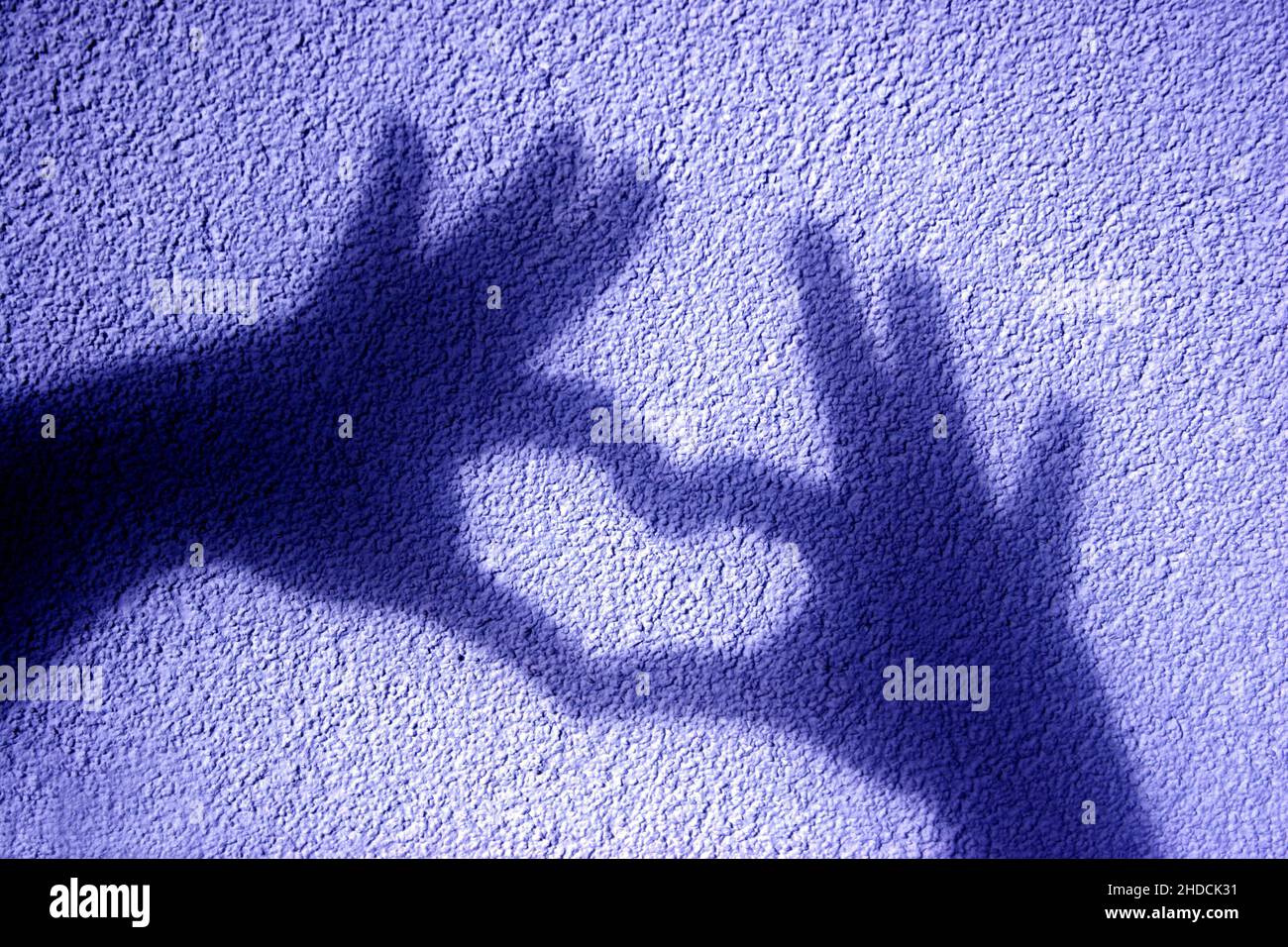 Schattenspiel, Schatten zweier Hände formen ein Herz auf eine Mauer, Foto Stock