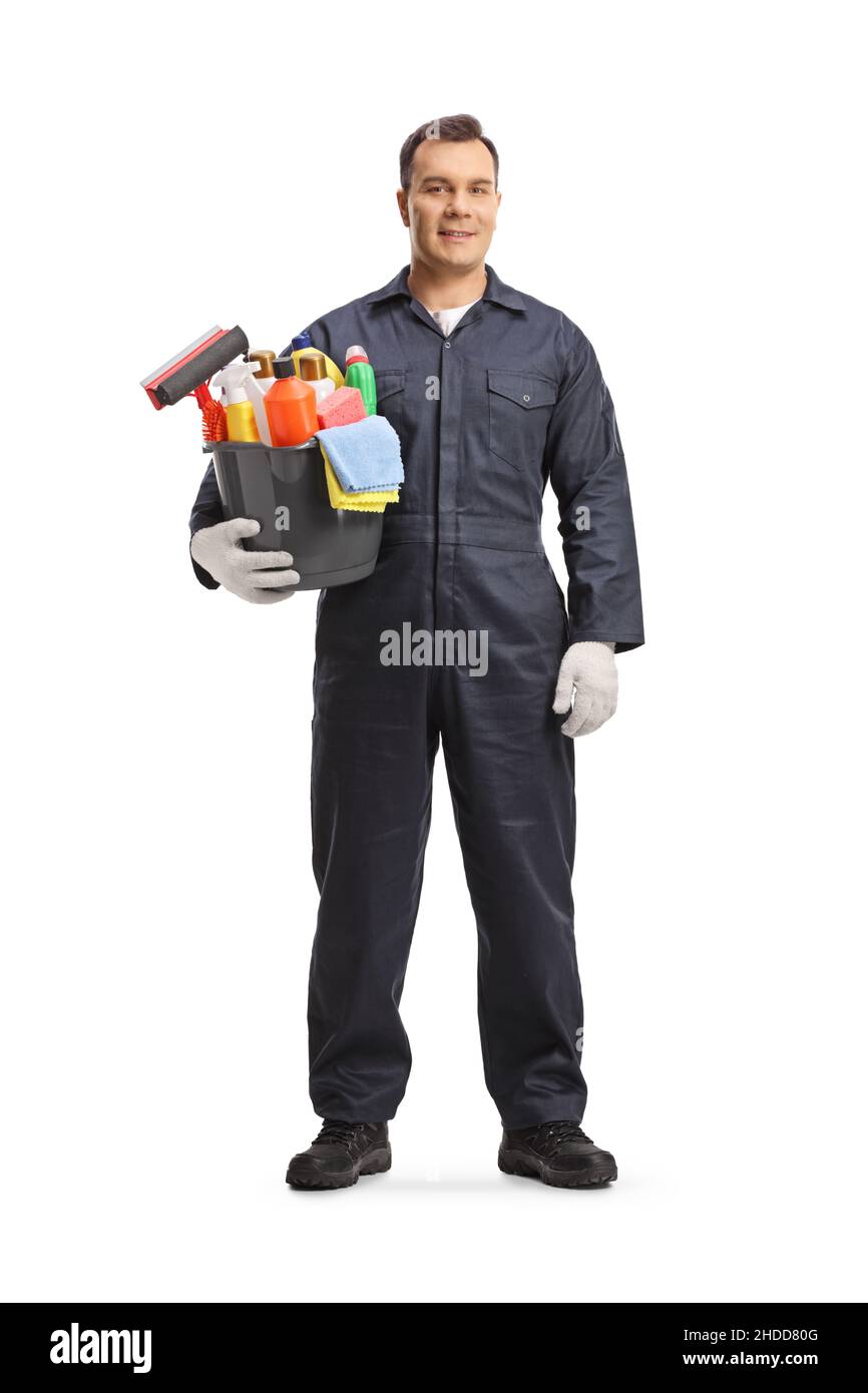 Ritratto a tutta lunghezza di un pulitore maschio professionale in posa uniforme con un secchio di forniture per la pulizia isolato su sfondo bianco Foto Stock