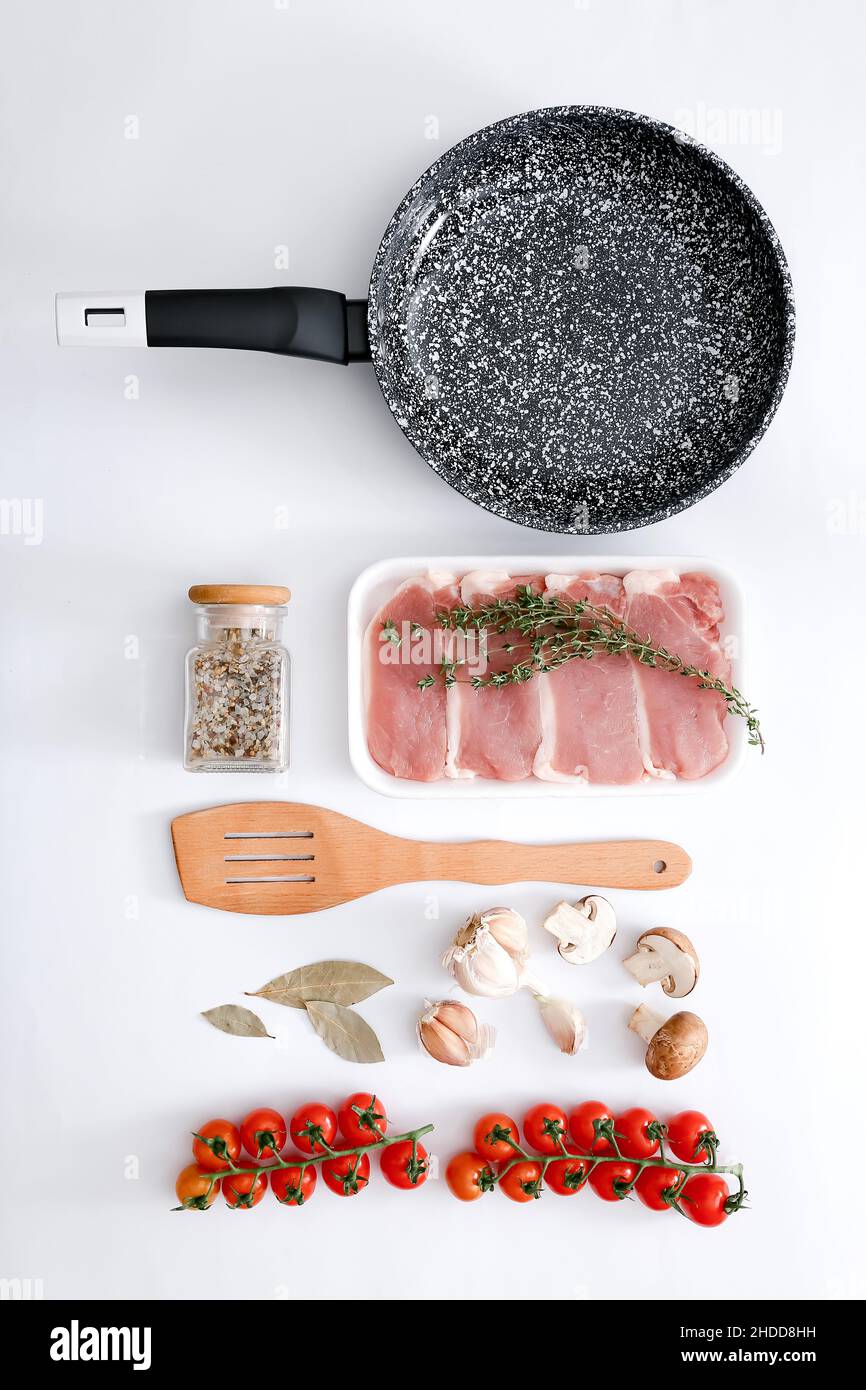 Padella in marmo nero con prodotti su sfondo grigio chiaro, vista dall'alto Foto Stock